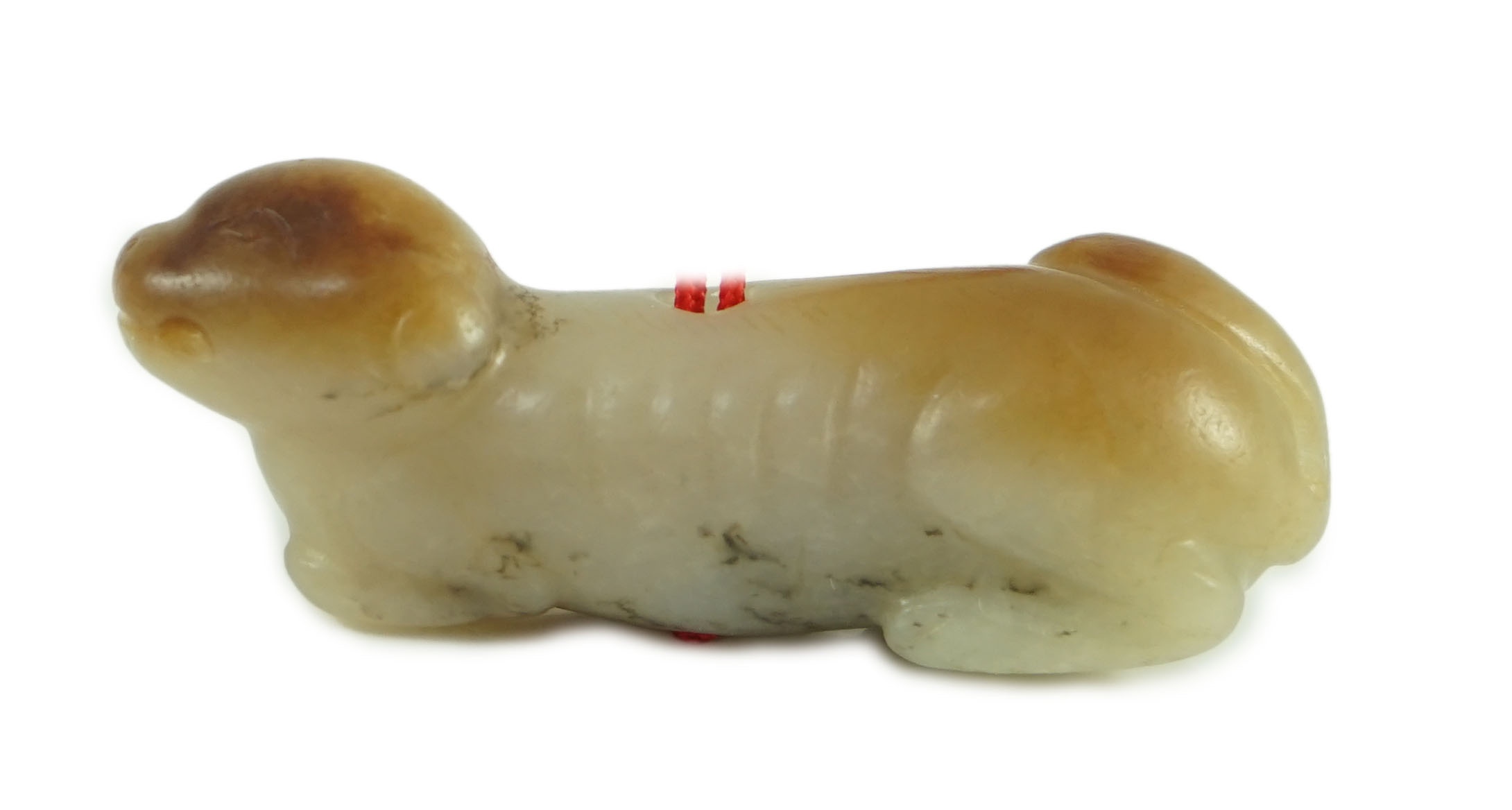 A Chinese pale grey and russet jade figure of a hound, probably Song dynasty, 4.9 cm long                                                                                                                                   