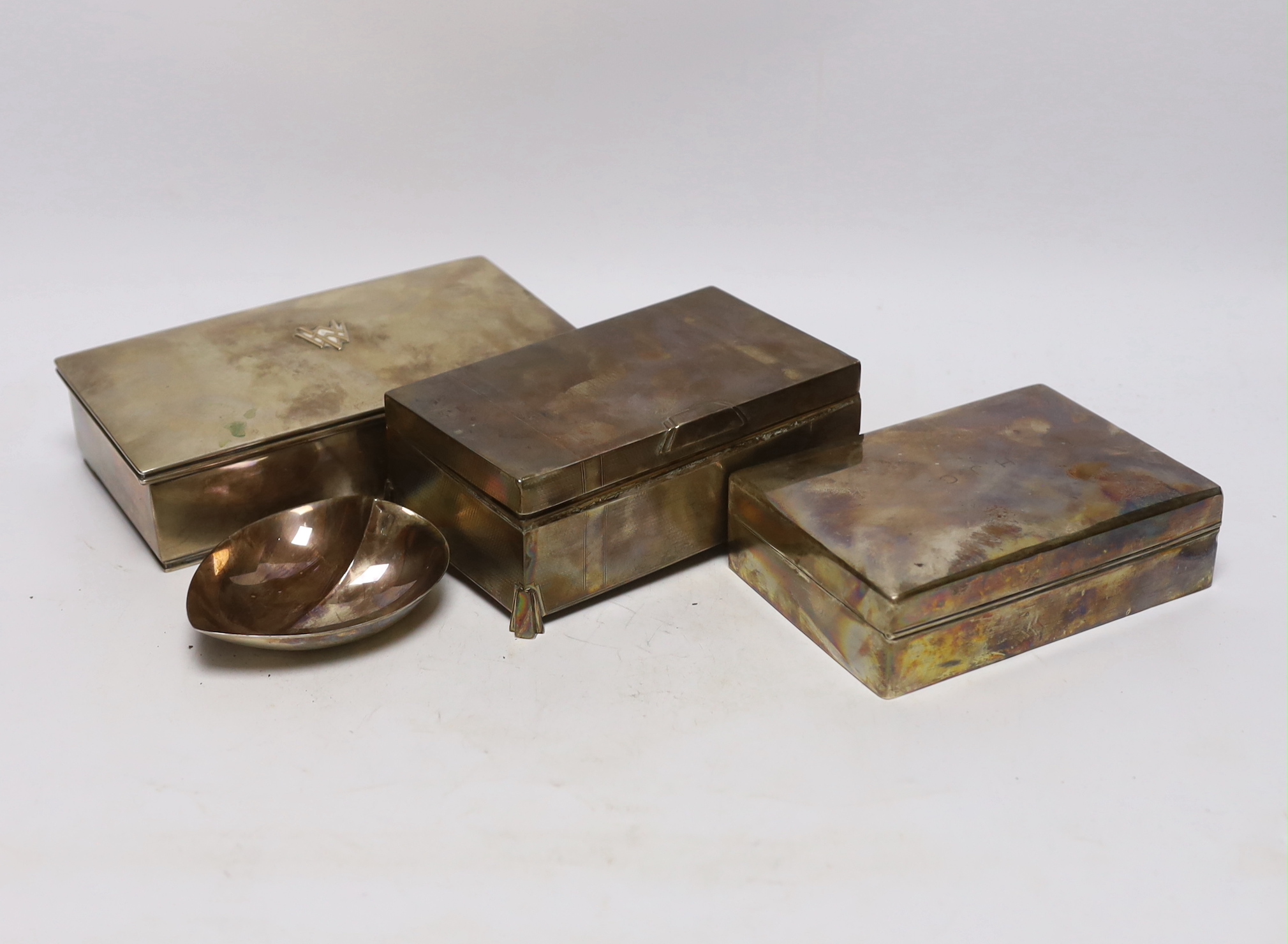 Two silver mounted cigarette boxes, including Art Deco, 15.2cm, together with a Finnish white metal mounted cigarette box and heart shaped dish.                                                                            