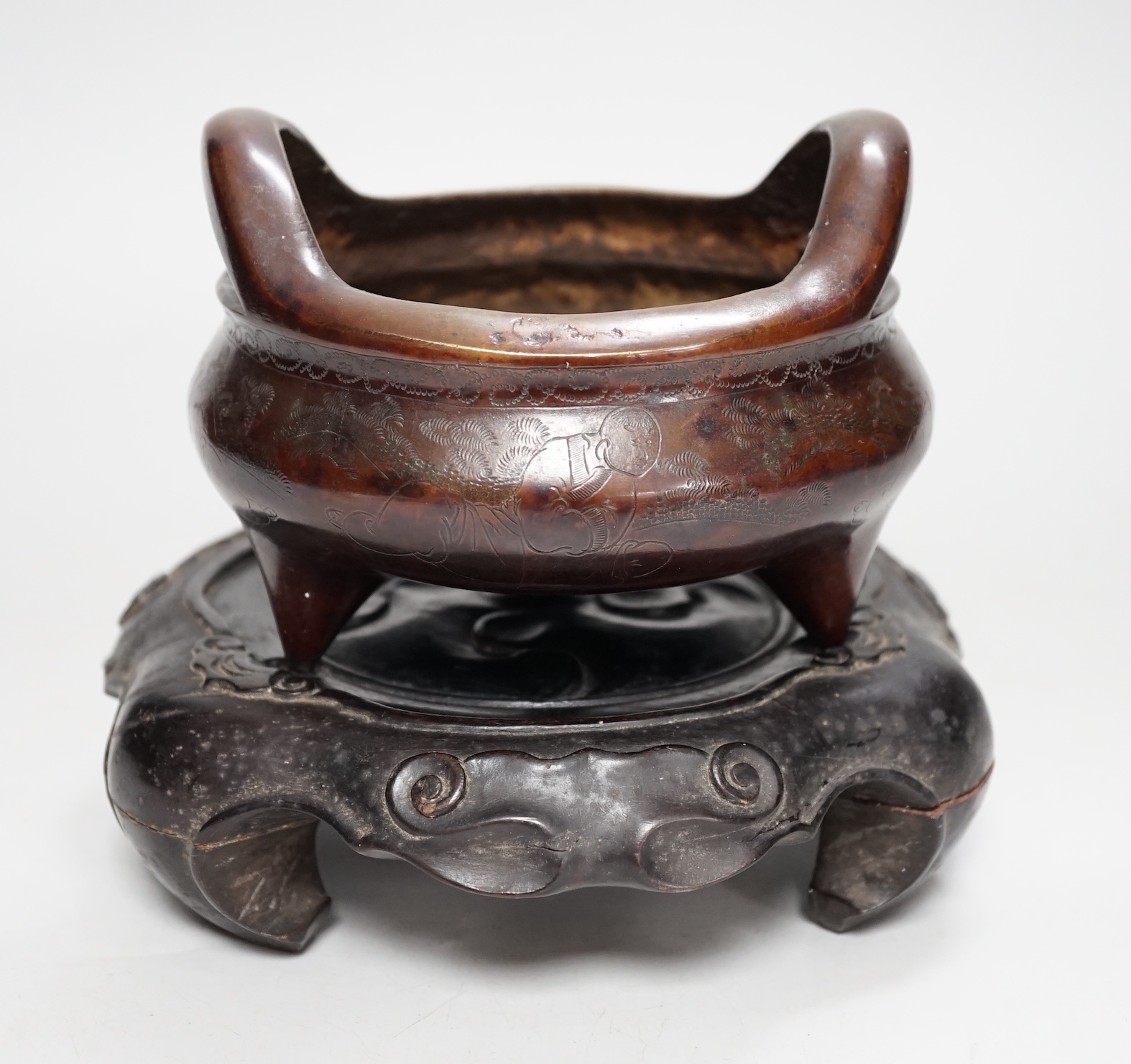 A Chinese bronze censer, with engraved detail, on hardwood stand, censer 16cm diam.                                                                                                                                         