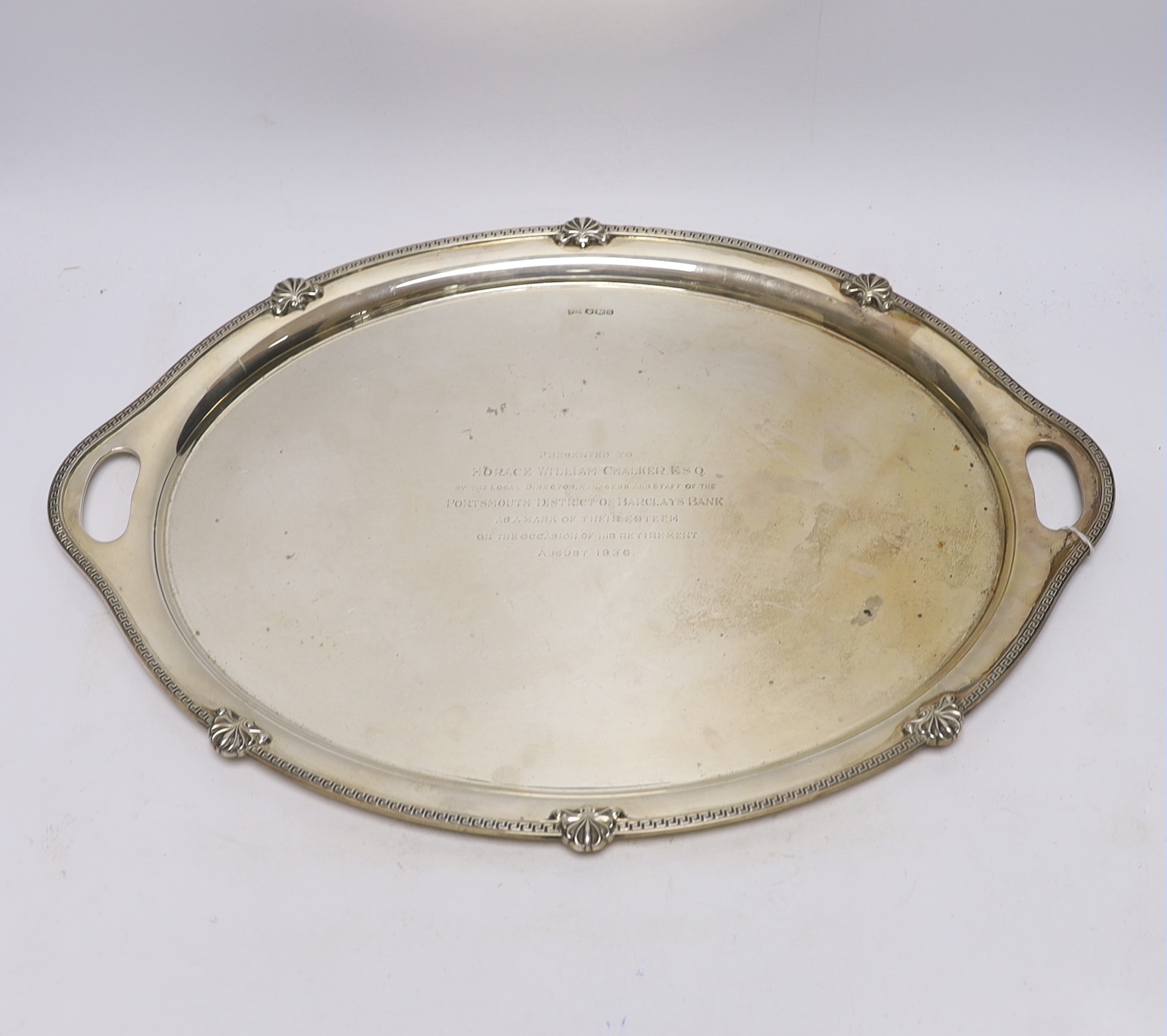 A George V silver oval presentation tea tray, with inset handles, Walker & Hall, Sheffield, 1935, 49.4cm, 54.2oz.                                                                                                           