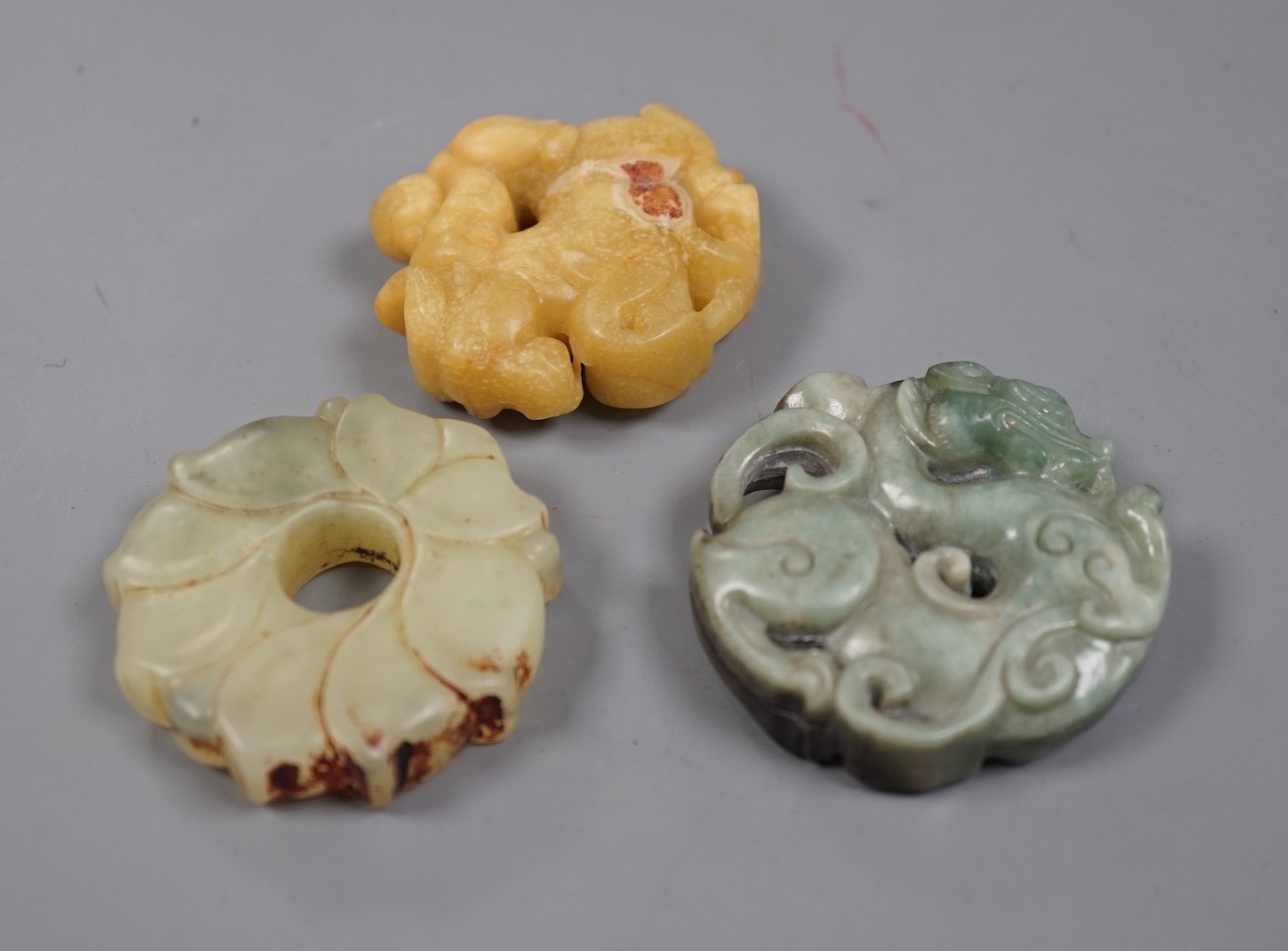 Three Chinese russet jade or hardstone bi discs                                                                                                                                                                             