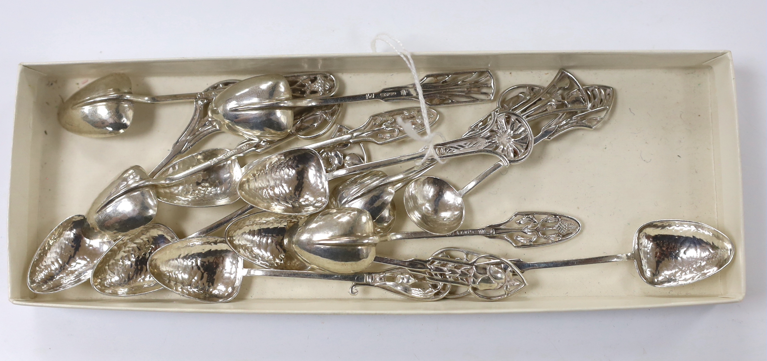 Fourteen Australian Arts & Crafts small sterling spoons by James A. Linton, with planished bowls and differing floral terminals, largest 86mm, 3.4oz.                                                                       