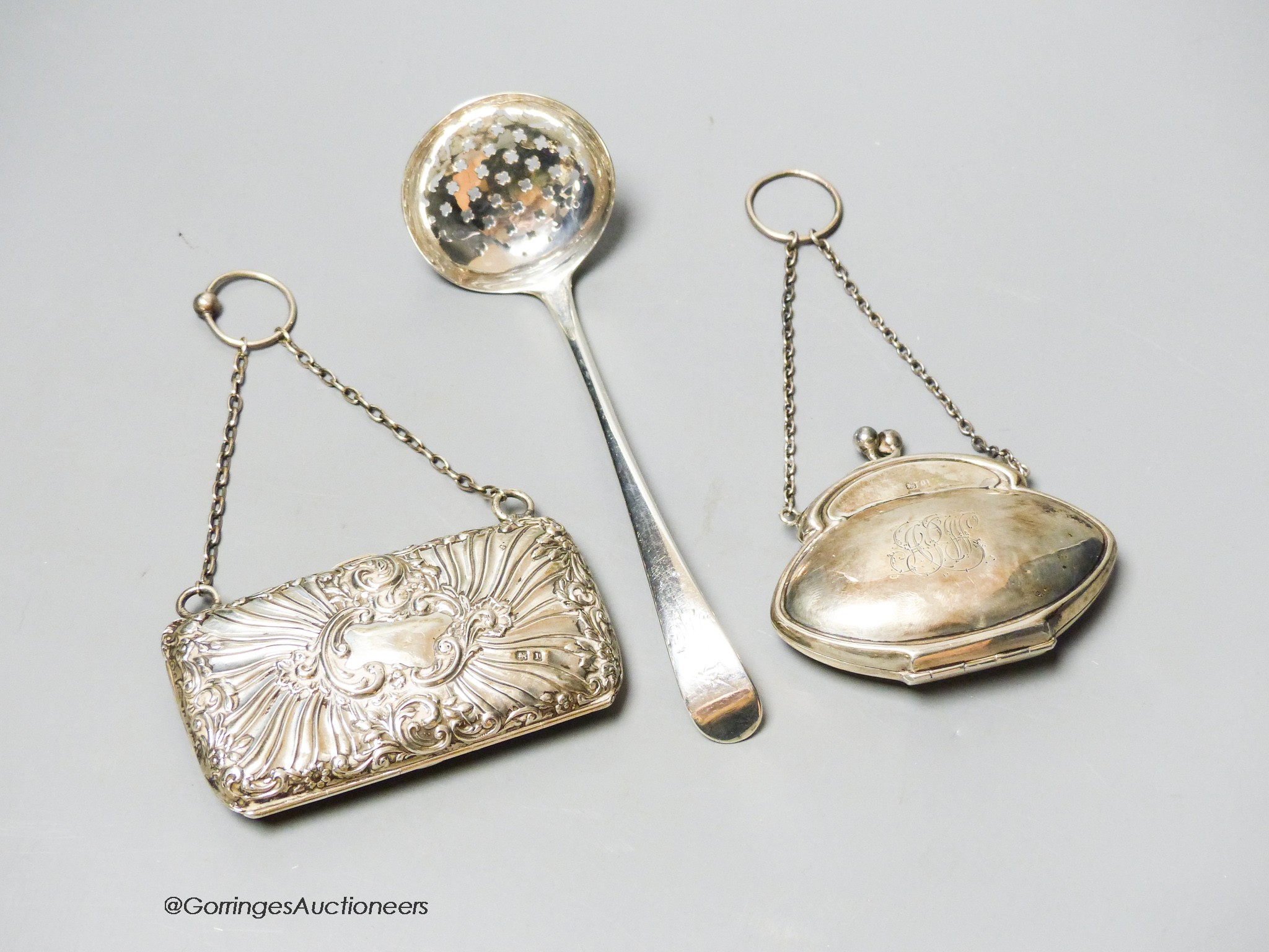 A George III silver sifter spoon, London, 1780?, 16cm and two George V silver mounted purses.                                                                                                                               