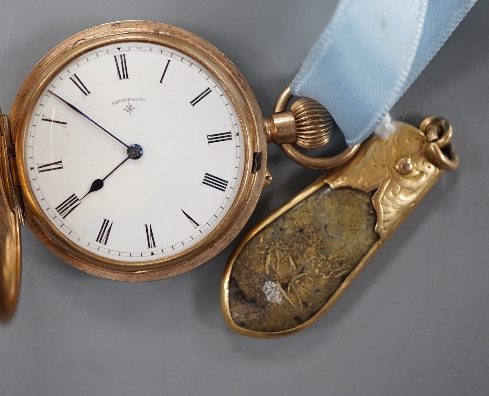 An early 20th century engraved 9ct gold hunter fob watch, with Roman dial, gross 36.7 grams, on a blue sash with yellow metal mounted hardstone fob.                                                                        