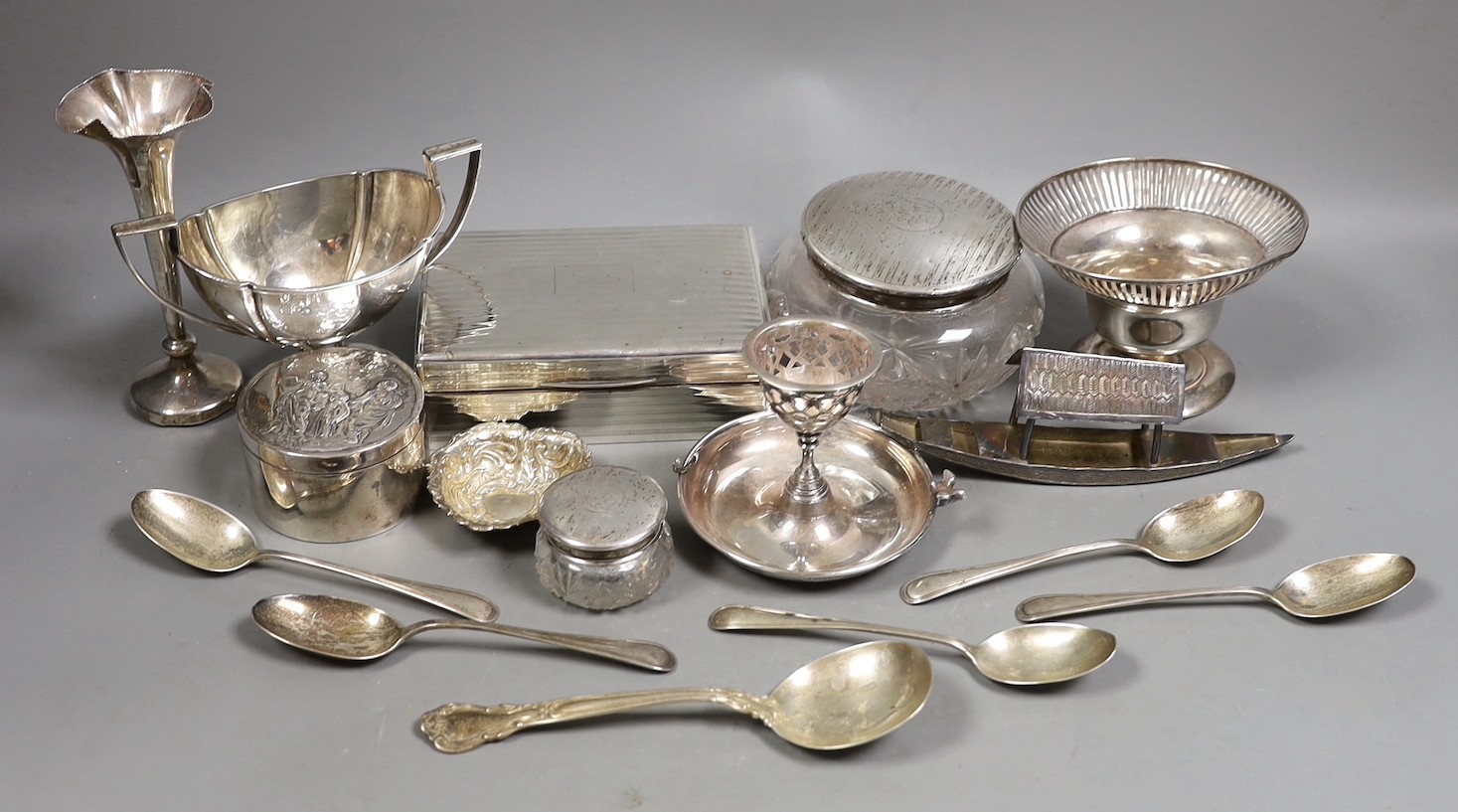 Miscellaneous silver ware including a mounted cigarette box, mounted posy vase, egg cup stand, late Victorian circular box and cover, repousse dish, eight sterling items including flatware and three other items.         