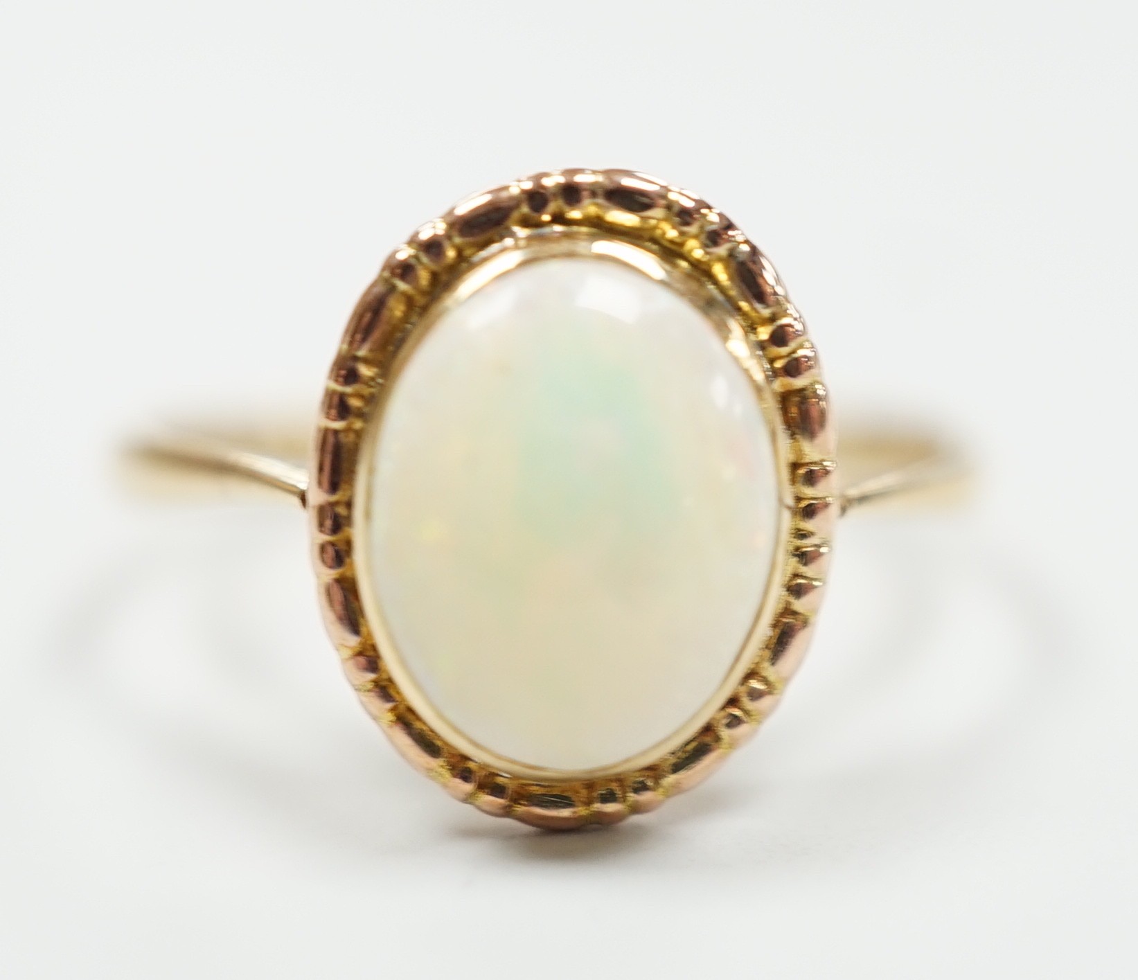 A yellow metal and oval white opal set ring, size Q, gross weight 2 grams.                                                                                                                                                  