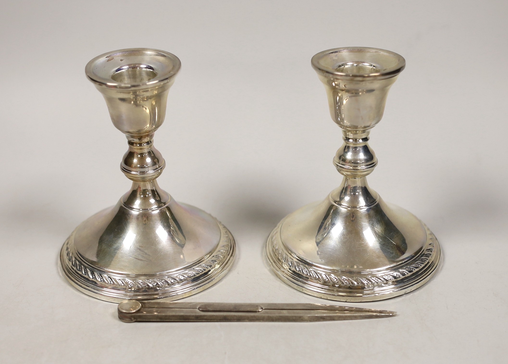 A pair of sterling mounted dwarf candlesticks, 11.9cm and a pair of modern silver compass dividers, maker, LP, London, 1990, 14.5cm.                                                                                        