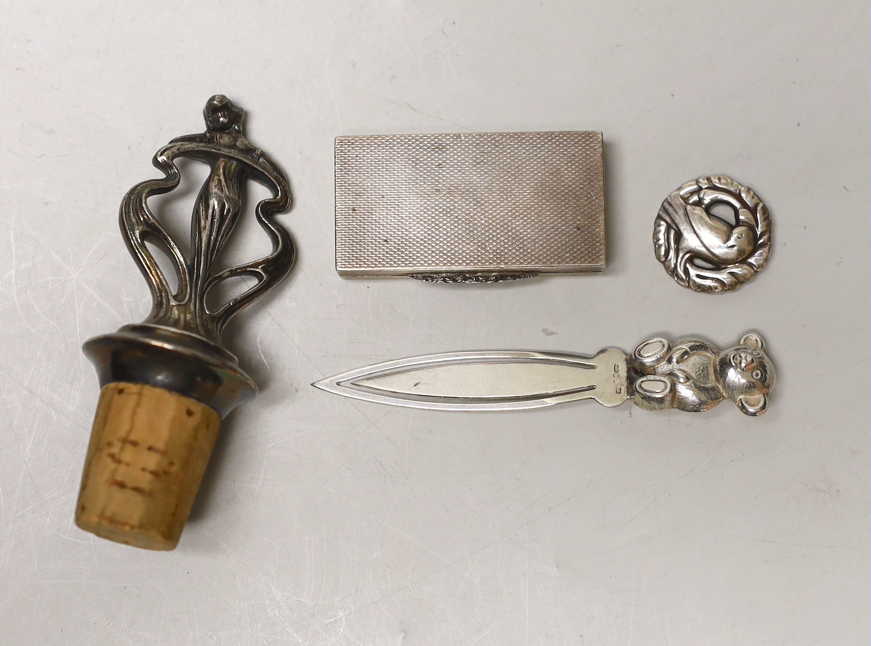 An Art Nouveau metal mounted cork stopper, a Georg Jensen sterling brooch, no. 191, an engine turned silver box and novelty bookmark.                                                                                       