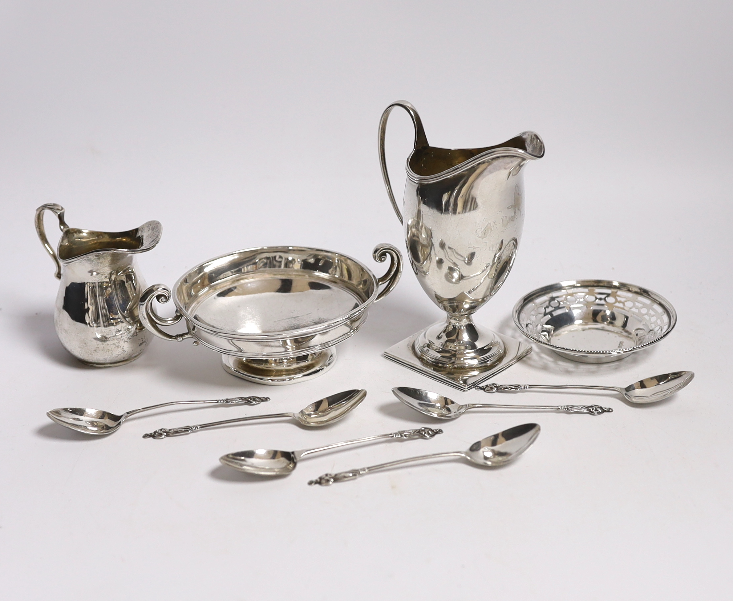 Two George V silver cream jugs, largest 12.5cm, a silver two handled pedestal bowl, a pierced small dish and set of six small silver coffee spoons.                                                                         