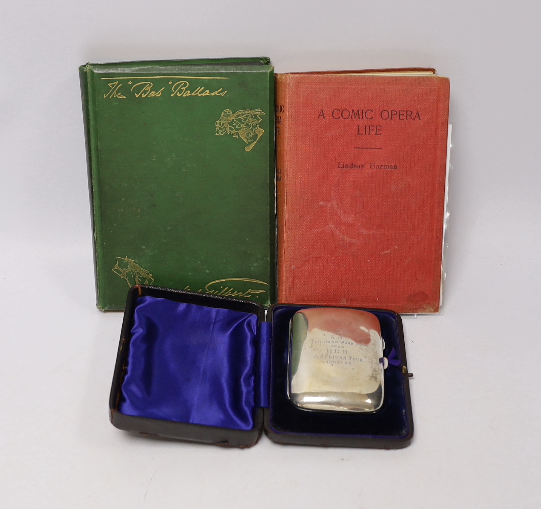 D’Oyly Carte interest; a cased silver cigarette case inscribed ‘To A.J. for hard work done from H.E.B. S. African Tour 1902-03, hallmarked Chester 1902, together with a signed Lindsay Harman, ‘A Comic Life’ and W.S. Gilb