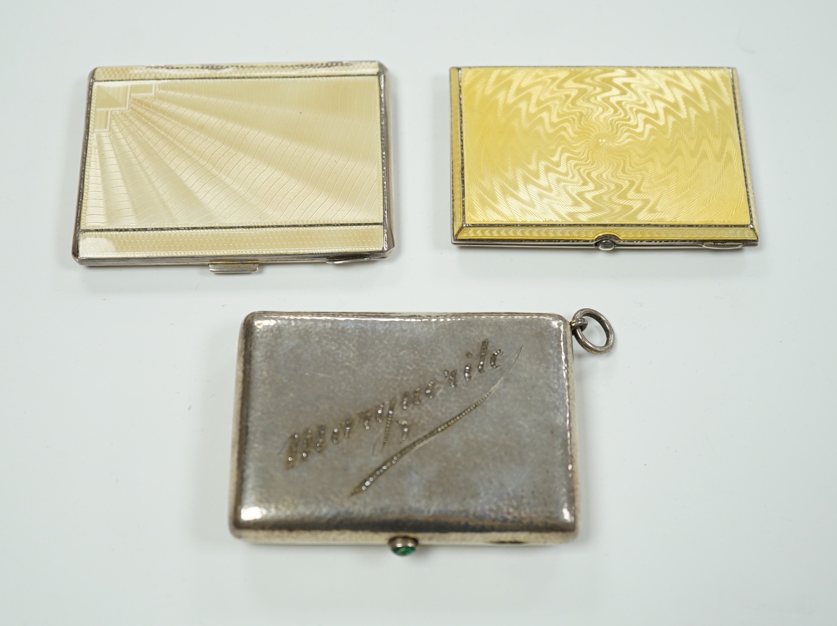 Two George V Art Deco silver and enamel cigarette cases, Birmingham, 1931 & 1932, largest 85mm (enamel a.f. on one) together with a German 800 standard white metal, cabochon emerald and rose cut diamond set compact/minau