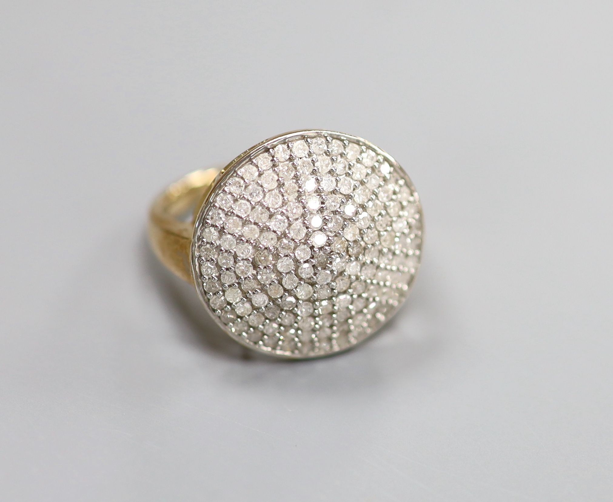 A modern 9kt and pave set diamond chip circular dress ring, size P, gross weight 4.8 grams.                                                                                                                                 