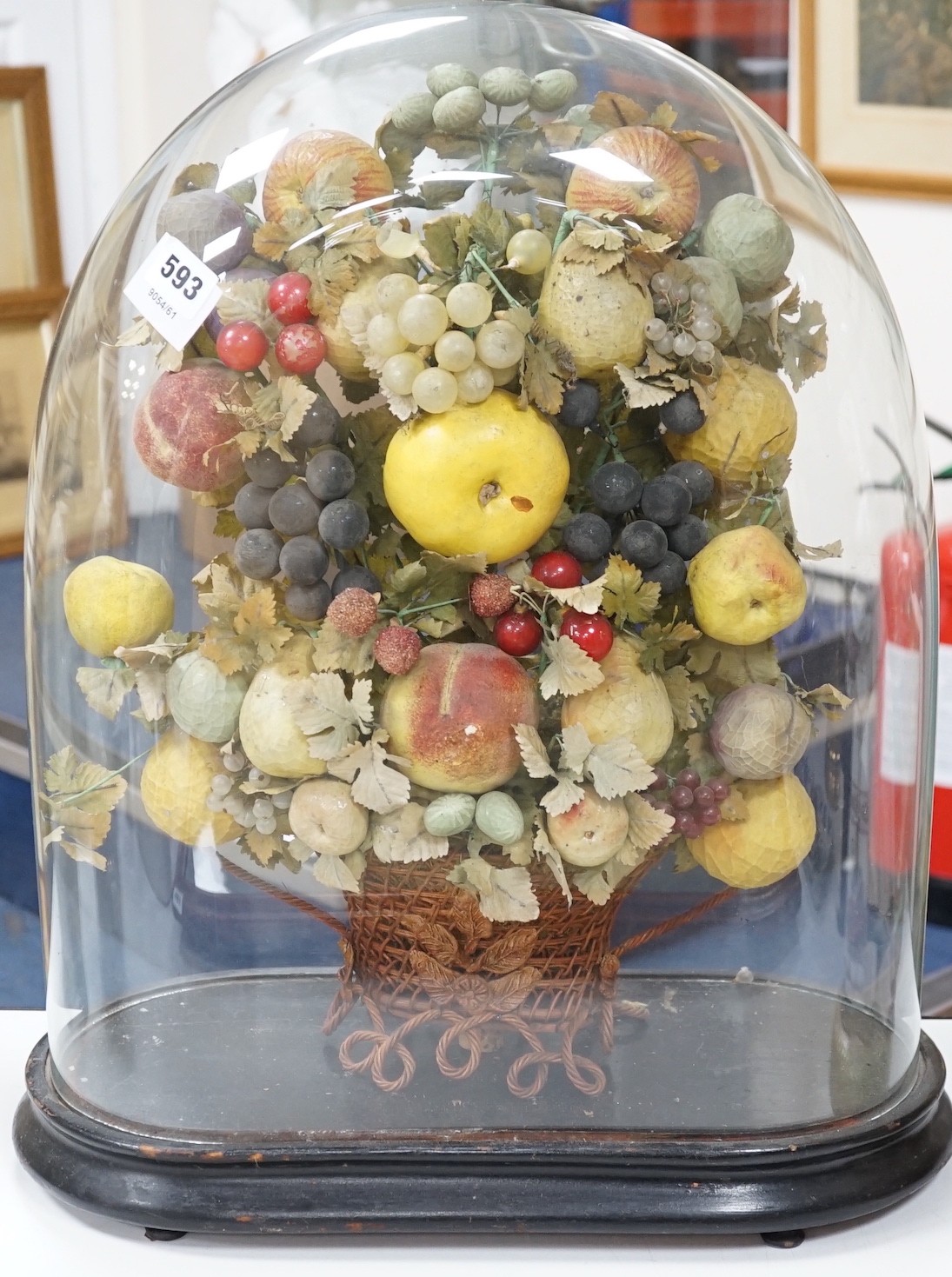 A Victorian display of papier mache fruit in a basket, under a glass dome, 55cms high                                                                                                                                       