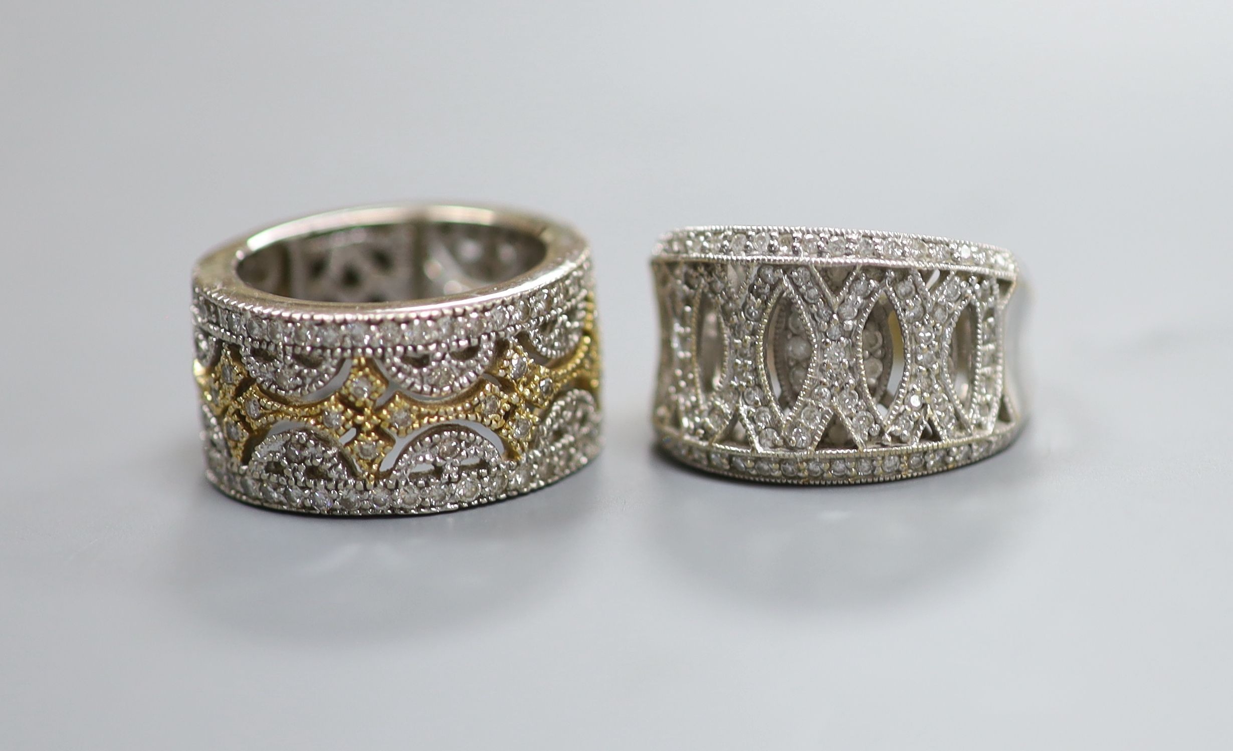 Two modern pierced yellow and white metal, diamond chip cluster rings, sizes K M, gross weight 18.9 grams.                                                                                                                  