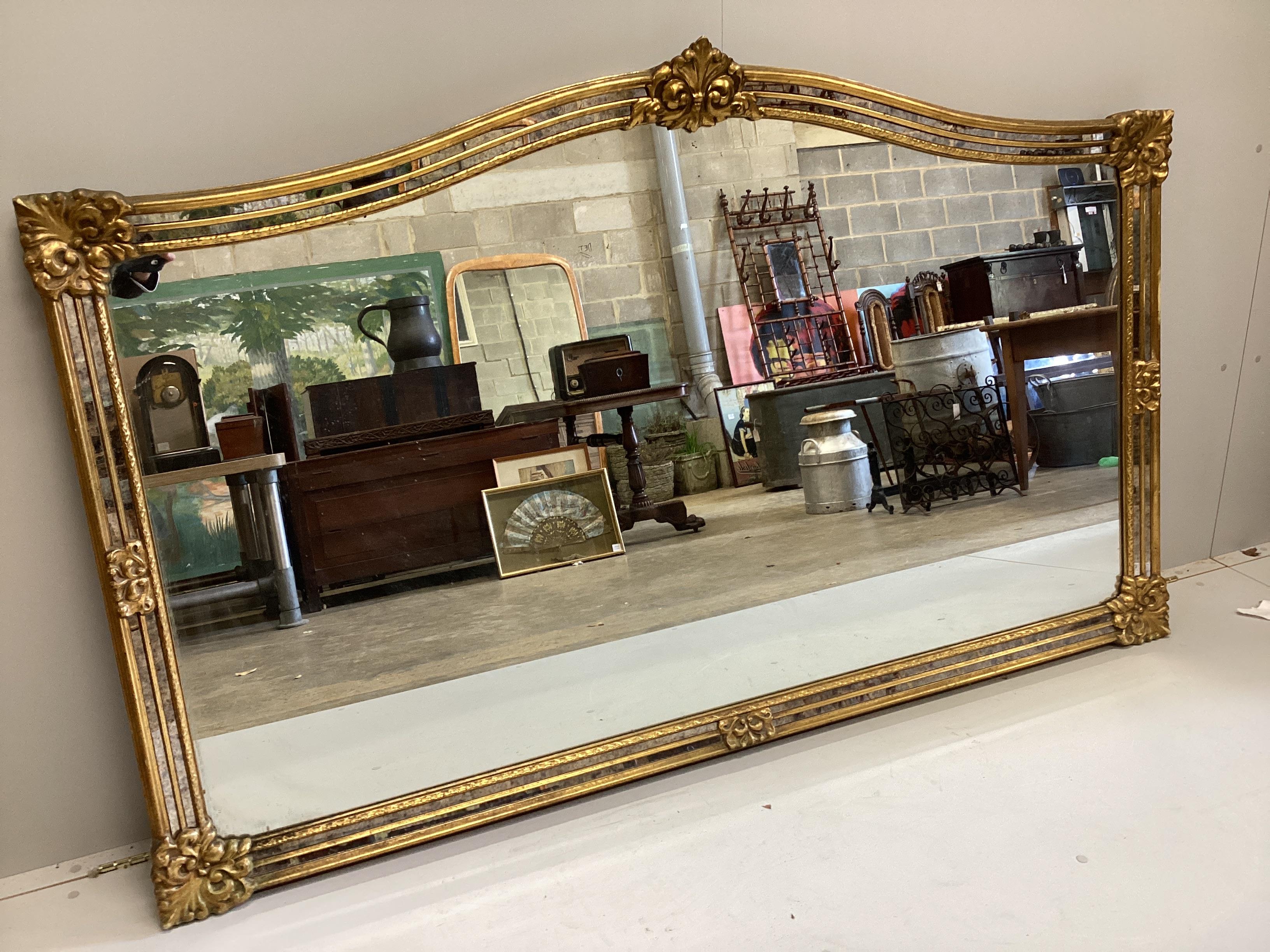 A Venetian style gilt framed overmantel mirror, width 184cm, height 114cm                                                                                                                                                   