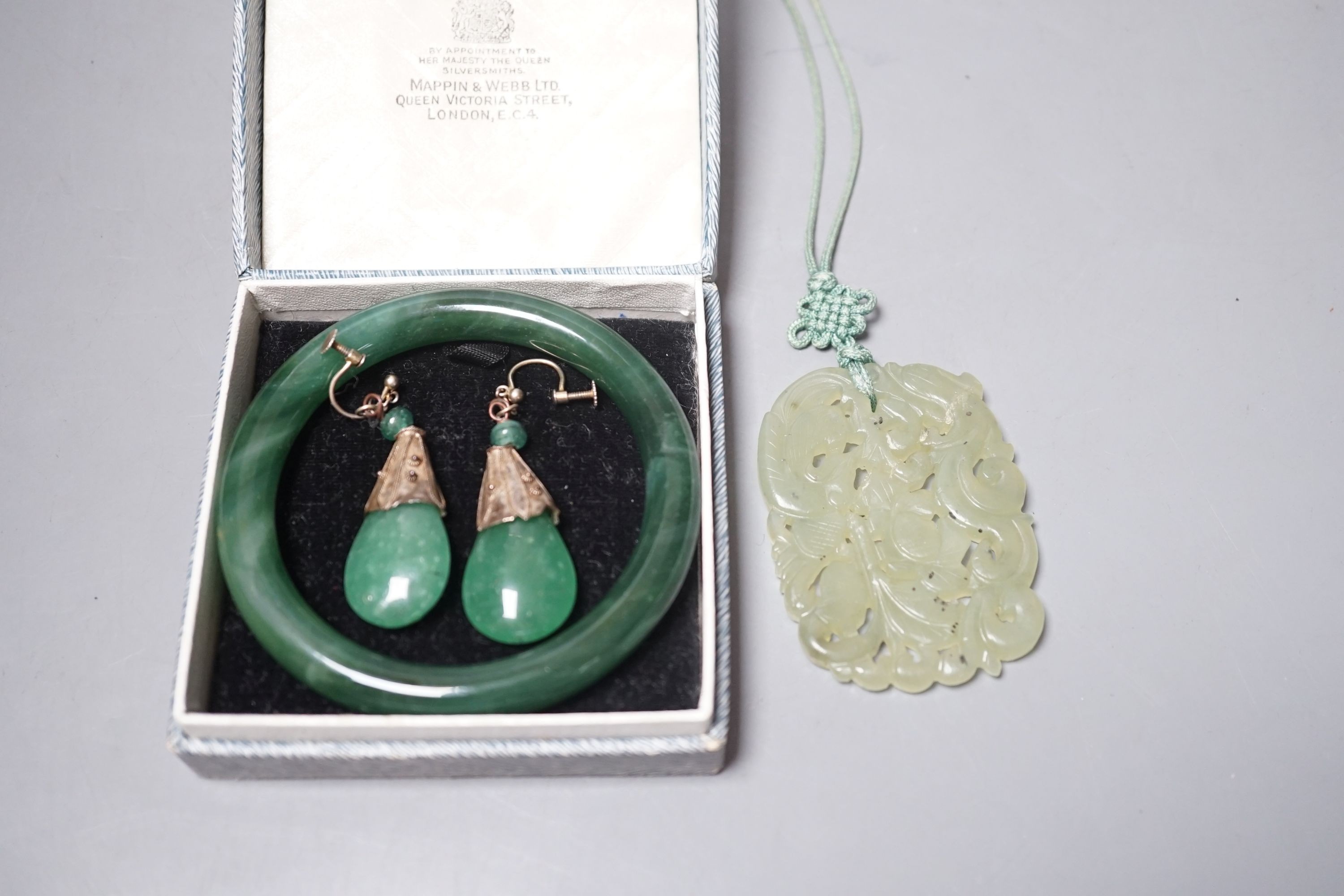 A Chinese carved bowenite jade pendant, a pair of green paste earrings and a green paste bangle.                                                                                                                            