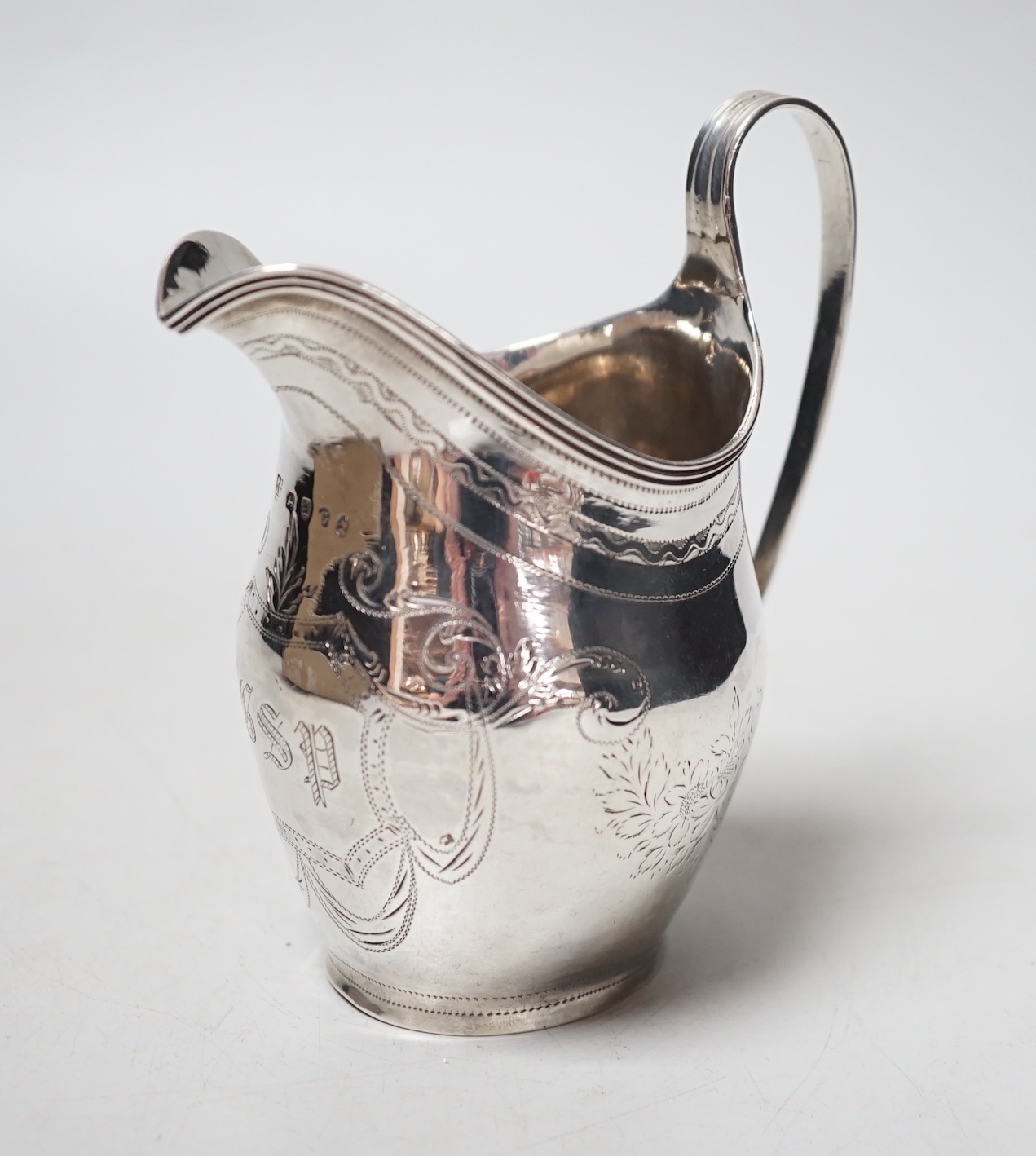 A George III engraved silver helmet shaped cream jug, Peter, Ann & William Bateman, London, 1802, 12.2cm, 108 grams.                                                                                                        