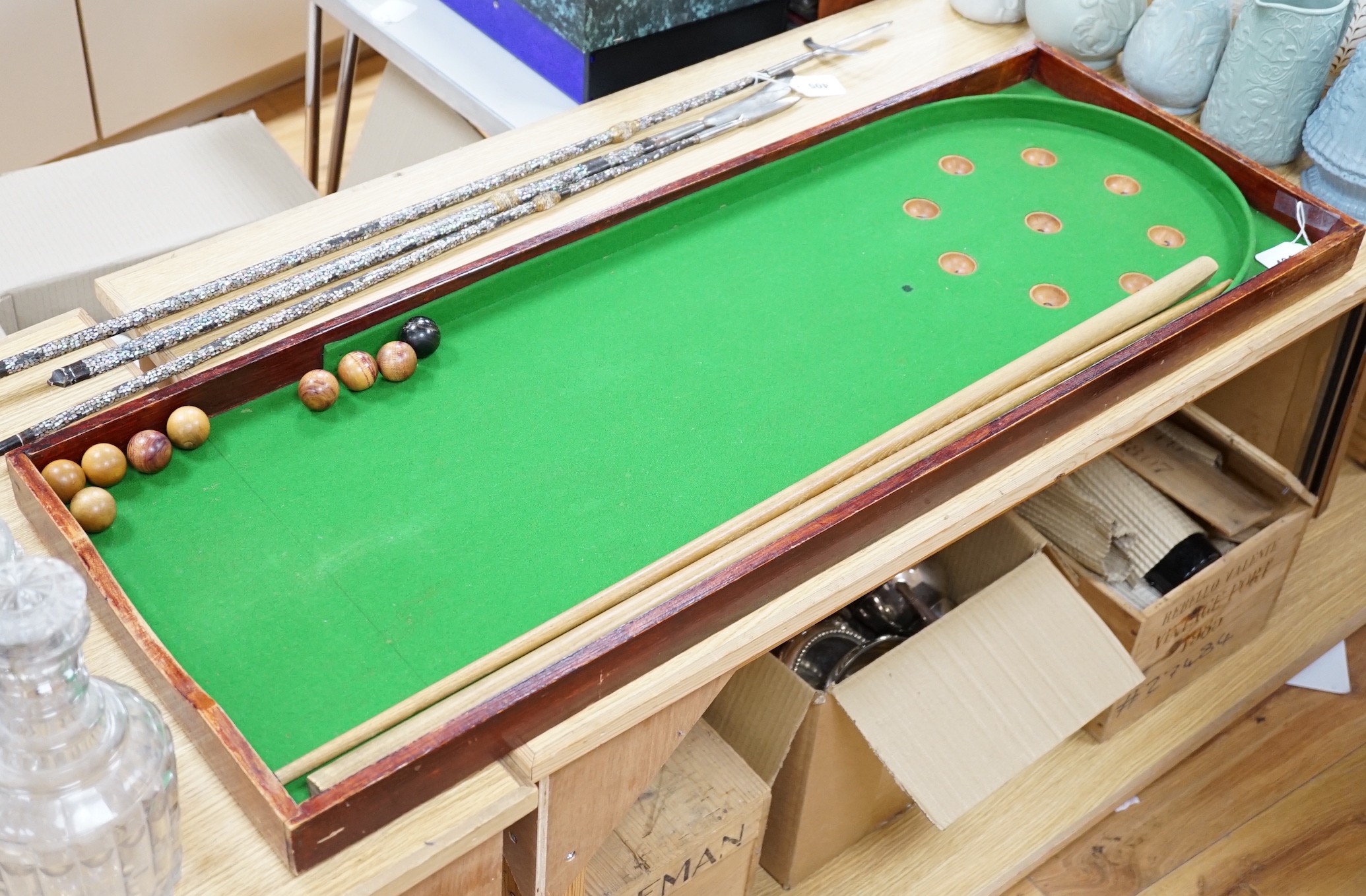 A bagatelle board, balls and cues, 108cm in length                                                                                                                                                                          