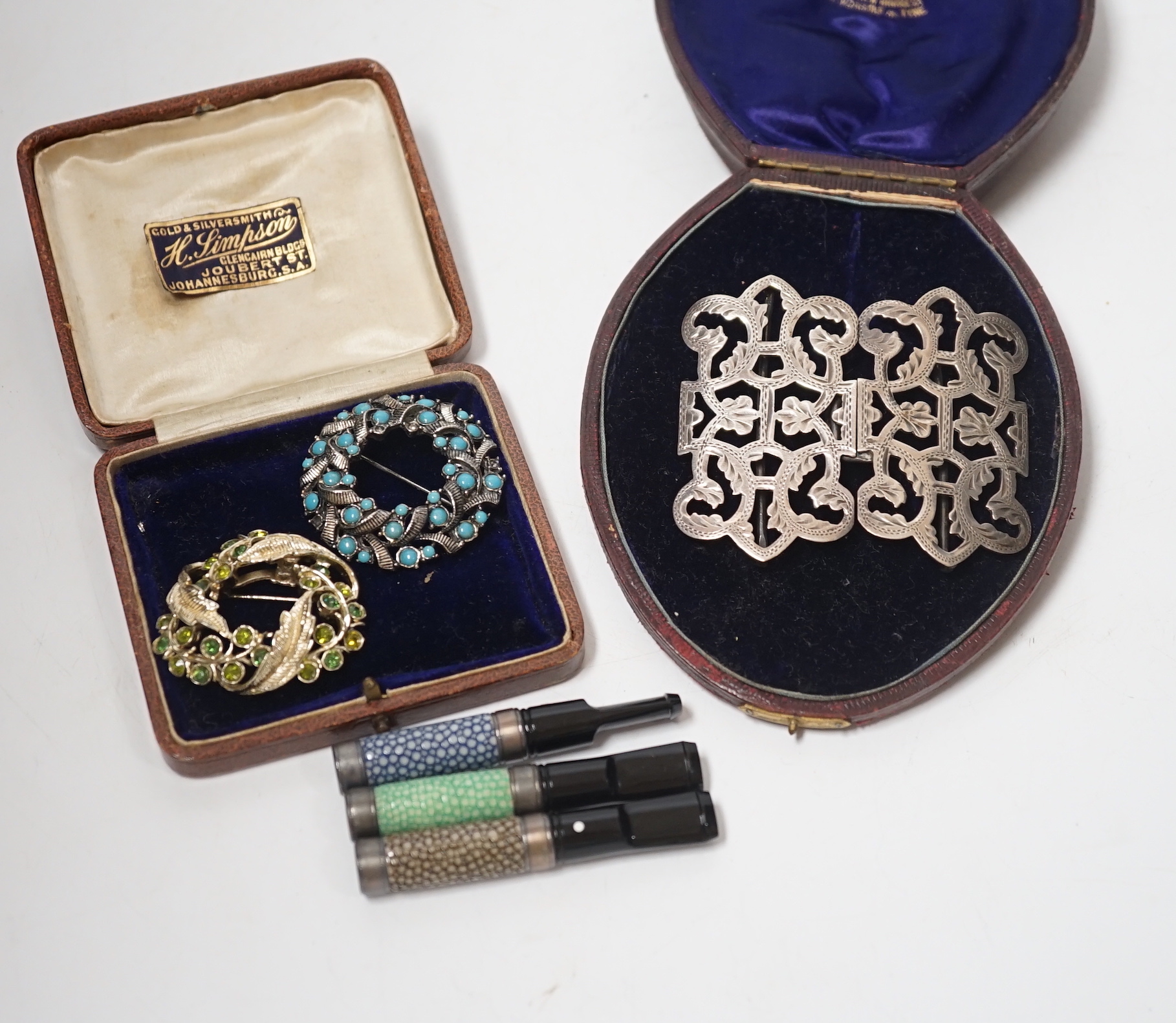 A late Victorian silver belt buckle, Birmingham, 1900, 72mm, three shagreen mounted cigarette holders and two costume brooches.                                                                                             