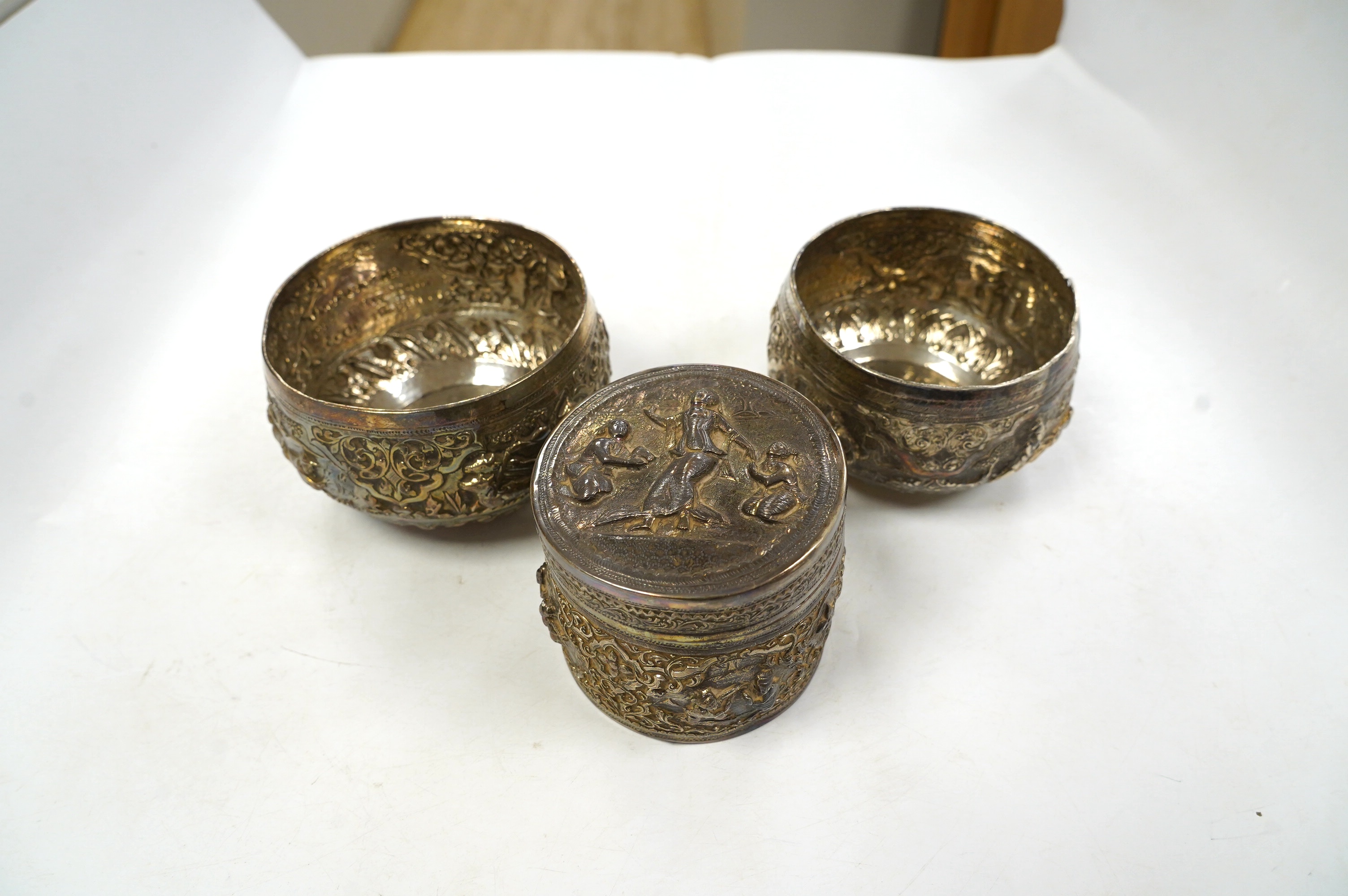 A pair of mid 20th century Indian embossed white metal small bowls, inscribed ' Agri-Horticultural Society Flower Show February 1953', diameter 10.4cm, together with a similar box and cover. Condition - poor to fair     