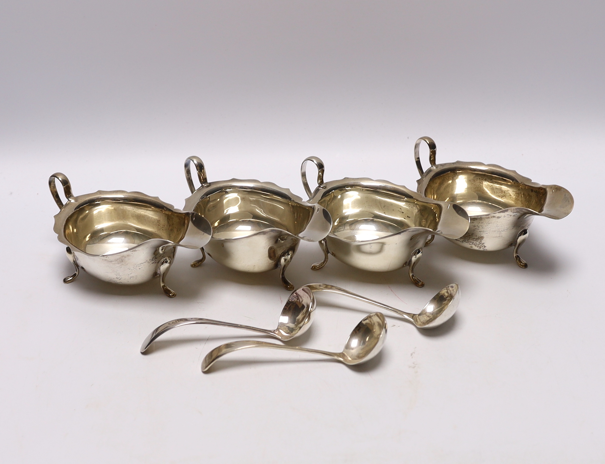 A set of three George VI silver sauceboats, Viners Ltd, Sheffield, 1937, together with three ladles (two silver) and one other silver sauceboat, 16.1oz.                                                                    