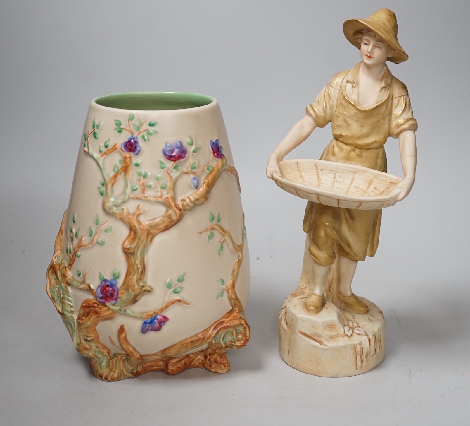 A Royal Dux figure of a water carrier and a Clarice Cliff for Newport Pottery vase. Tallest 27cm                                                                                                                            