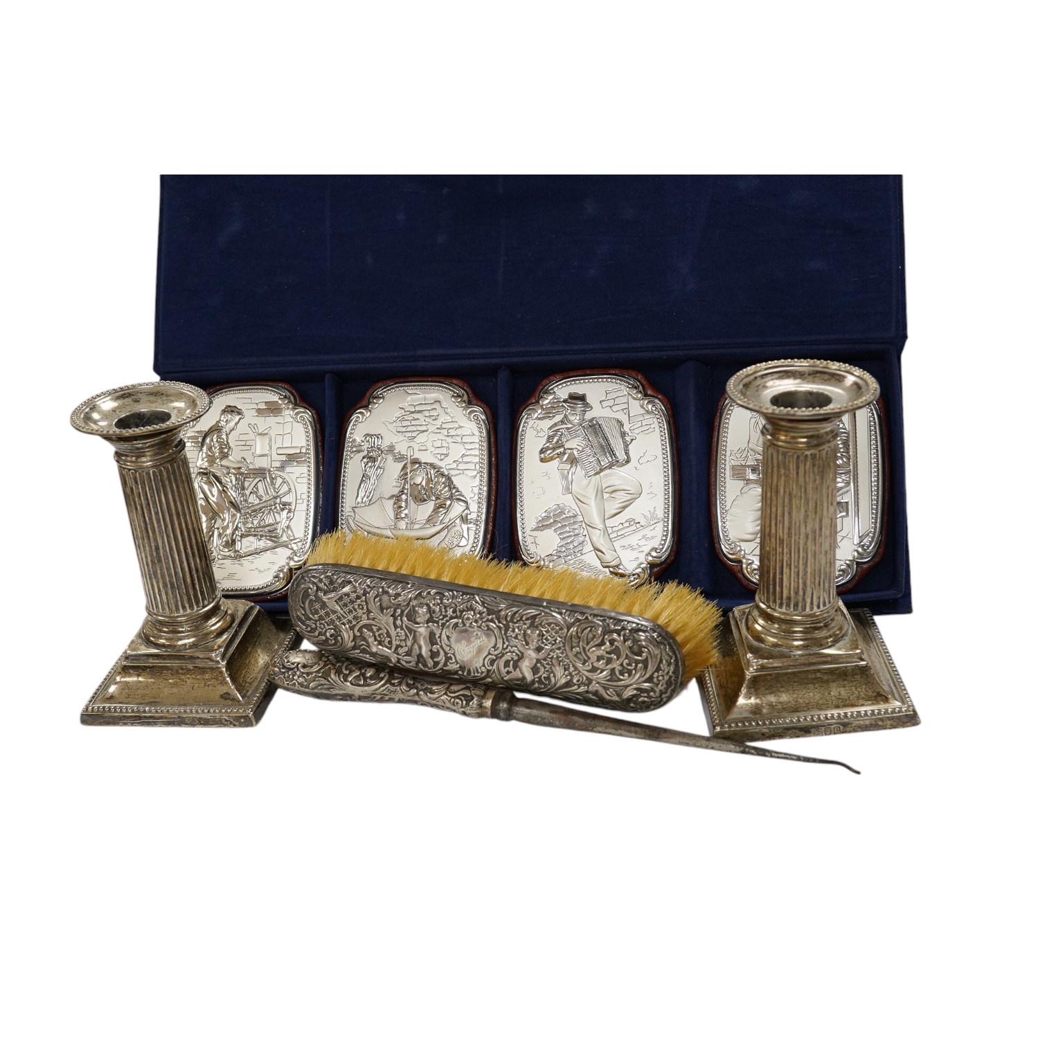 A pair of late Victorian silver dwarf candlesticks, by William Hutton & Sons, London, 1898, 13cm, weighted, together with a silver mounted button hook and clothes brush and a cased set of four 850 white metal mounted wal