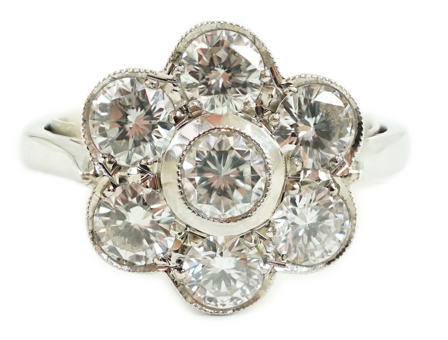 A platinum and seven stone diamond cluster set flower head ring                                                                                                                                                             