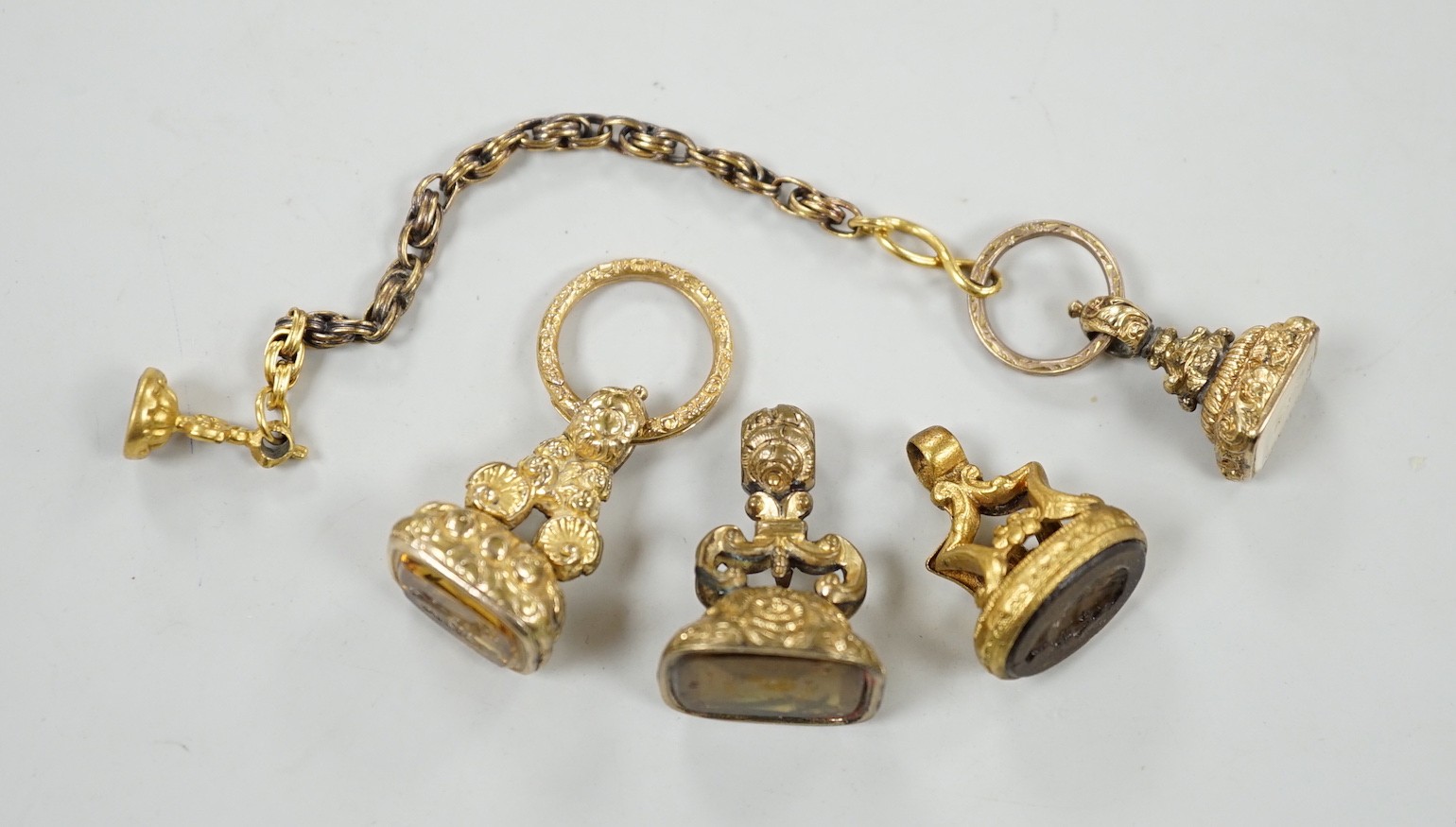 Four assorted 19th century gold plated fob seals, set with citrine, glass or carnelian, largest 30mm.                                                                                                                       