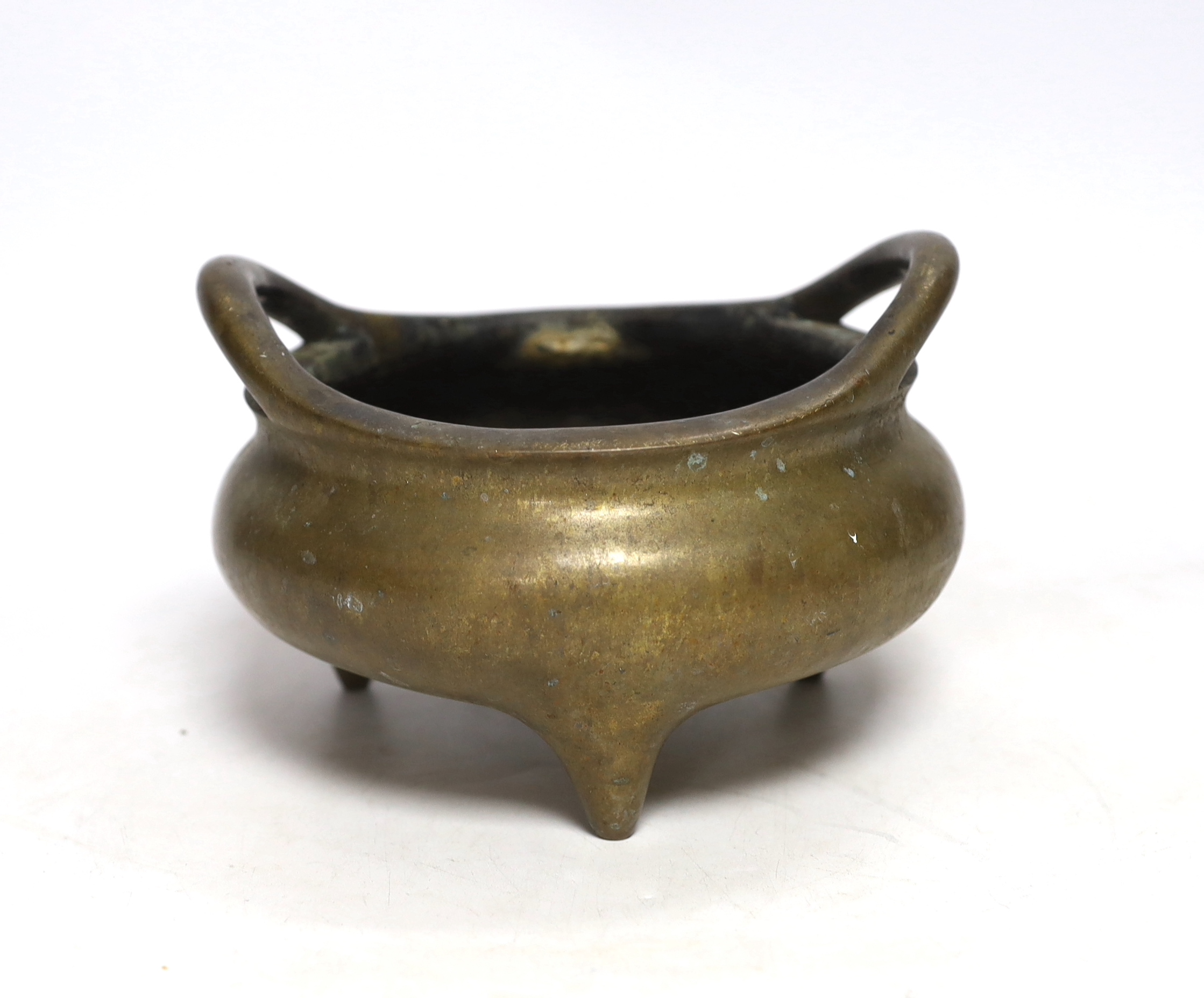 A Chinese bronze censer with twin handles and tripod feet, 18cm wide                                                                                                                                                        