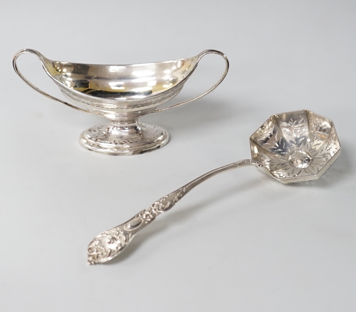 A George III two handled oval silver salt, makers initials CH, London 1791, 77 grams, and a Continental white metal sifter ladle                                                                                            