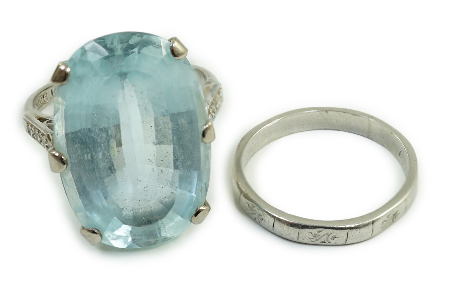 An 18ct, plat and single stone oval cut aquamarine set ring, with diamond chip set shoulders, size K, gross weight 7 grams, together with a white metal, stamped platinum, wedding band, size I, 2.8 grams.                 