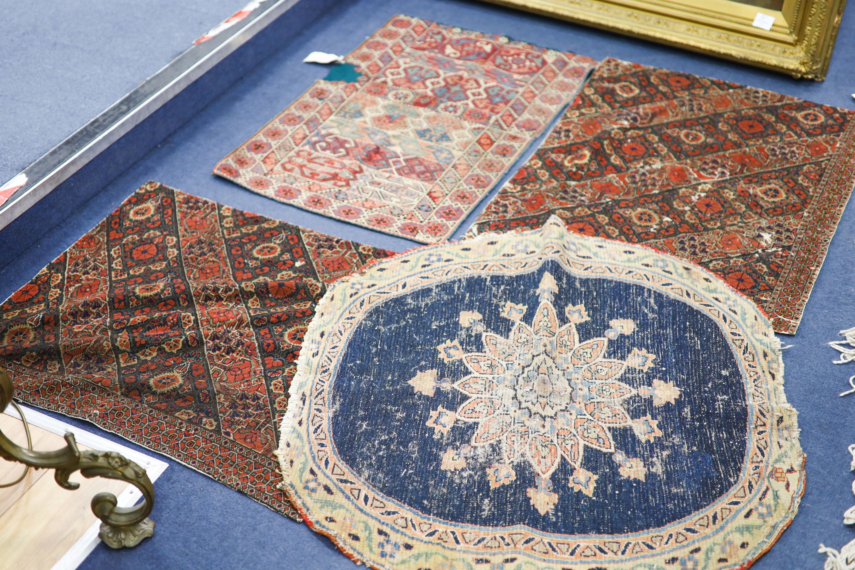An Ottoman cross stitch embroidered cloth, 84 x 57cm., a pair of Persian antique needlework panels, 80 x 65cm. and a circular small rug, 86cm.                                                                              