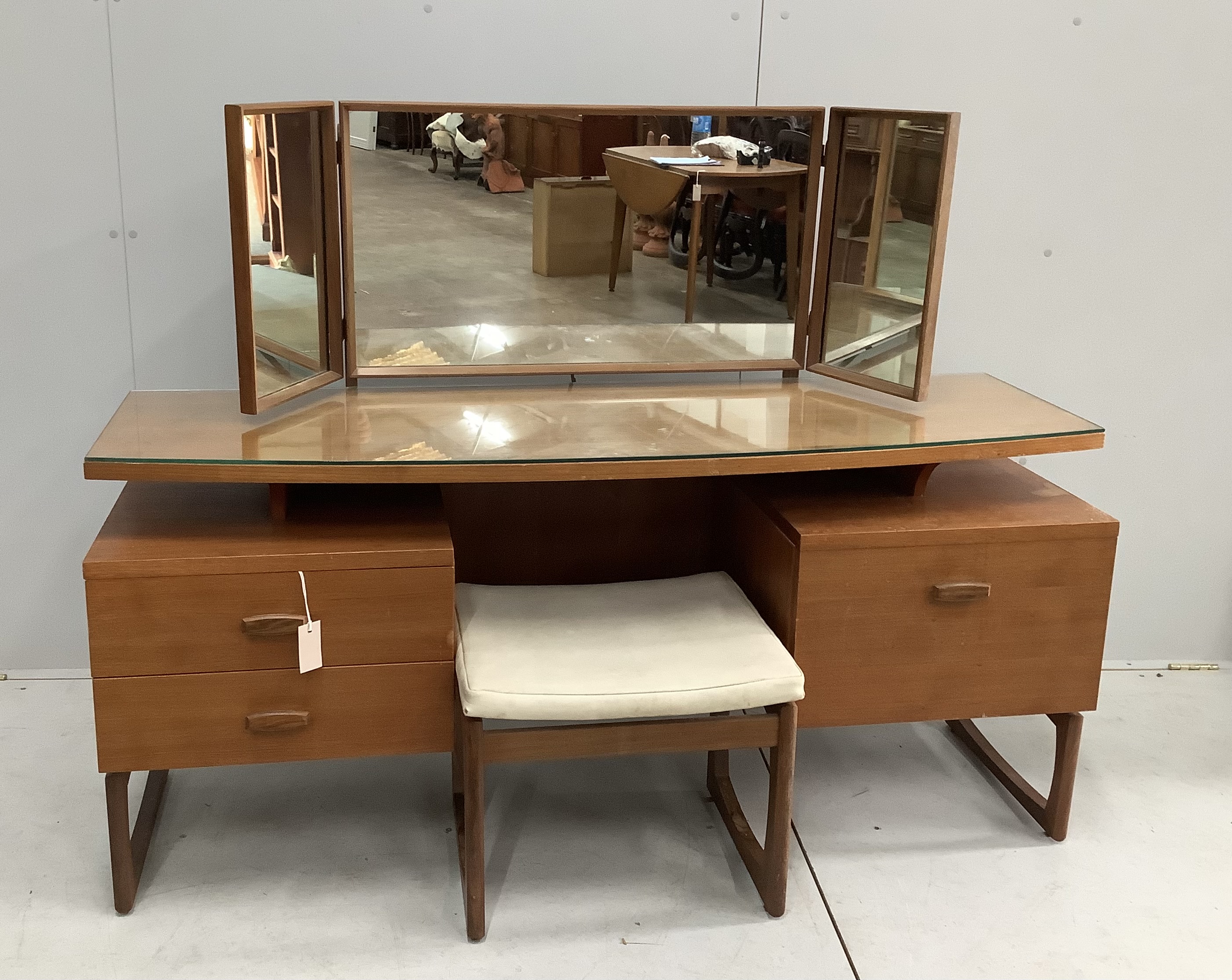 A mid century G Plan teak dressing table, width 152cm, depth 47cm, height 117cm and stool                                                                                                                                   