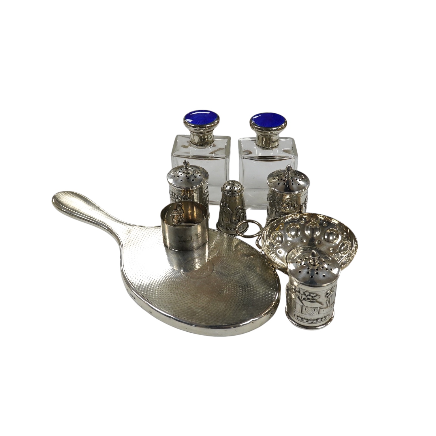 Small silver including a napkin ring, hand mirror and two mounted glass toilet jars, together with three Indian white metal condiments and a French white metal wine taster. Condition - poor to fair                       