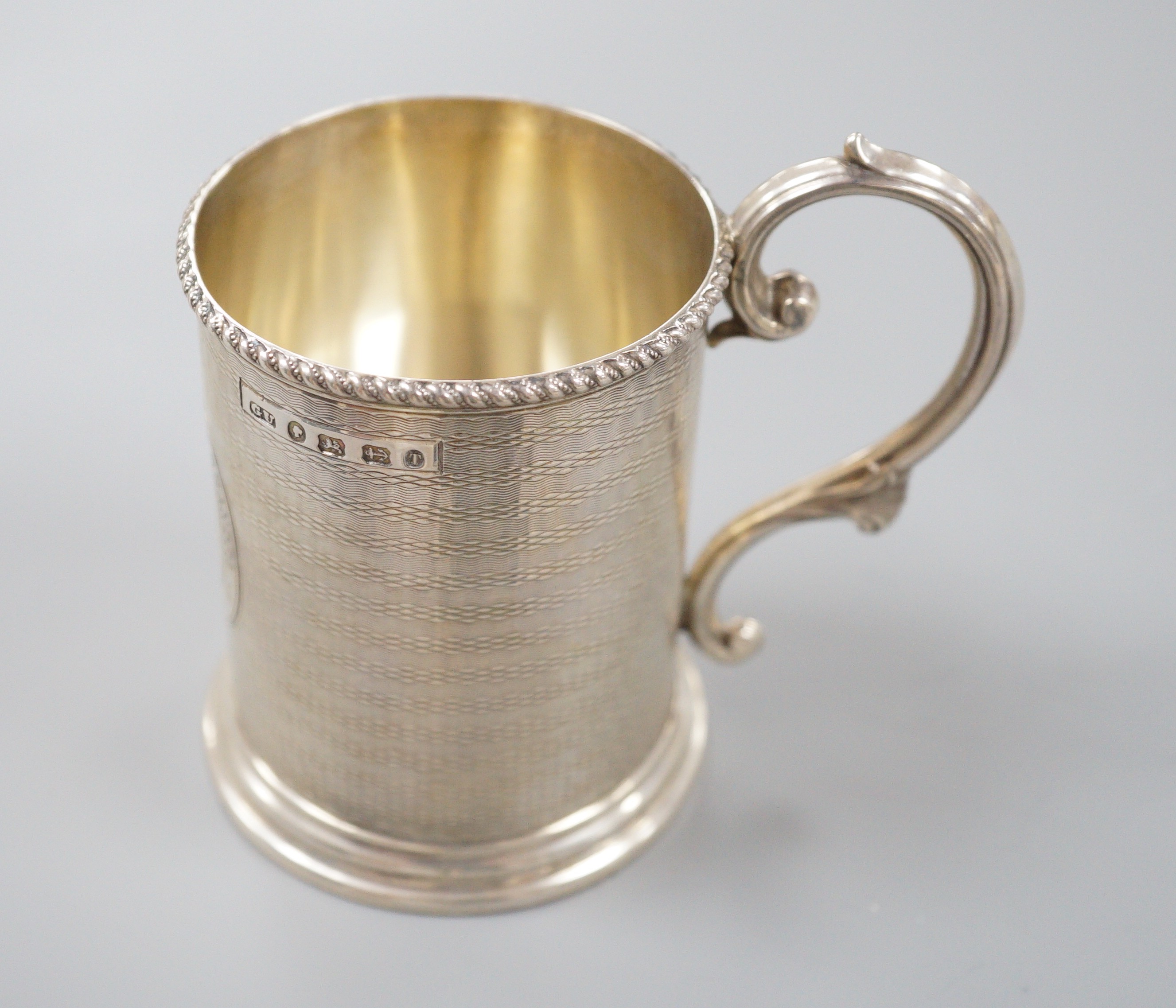 A Victorian engine turned silver christening mug, with engraved inscription, George Unite, Birmingham, 1868, 86mm.                                                                                                          