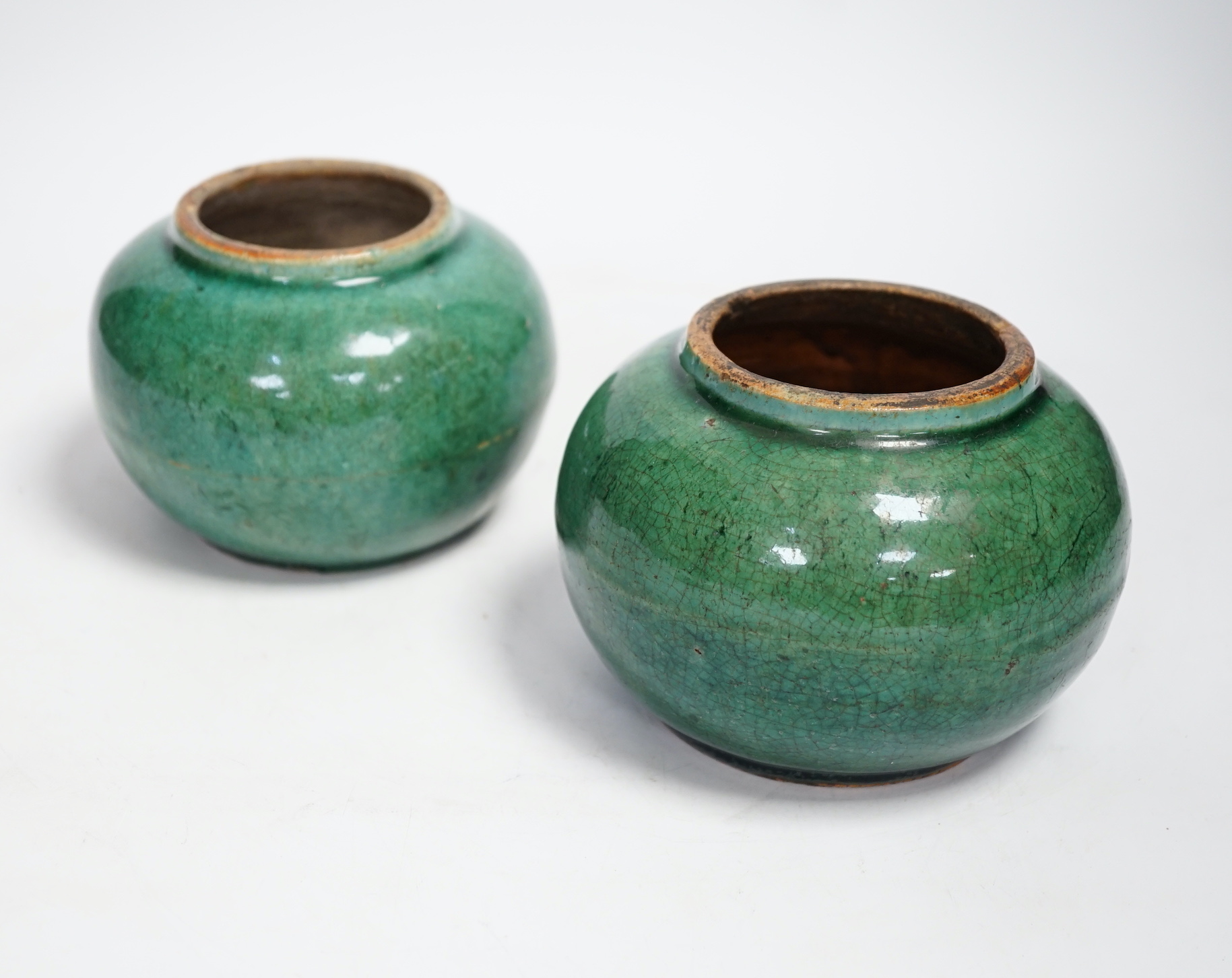 A pair of Chinese pottery monochrome green glazed jars, 10cm high                                                                                                                                                           