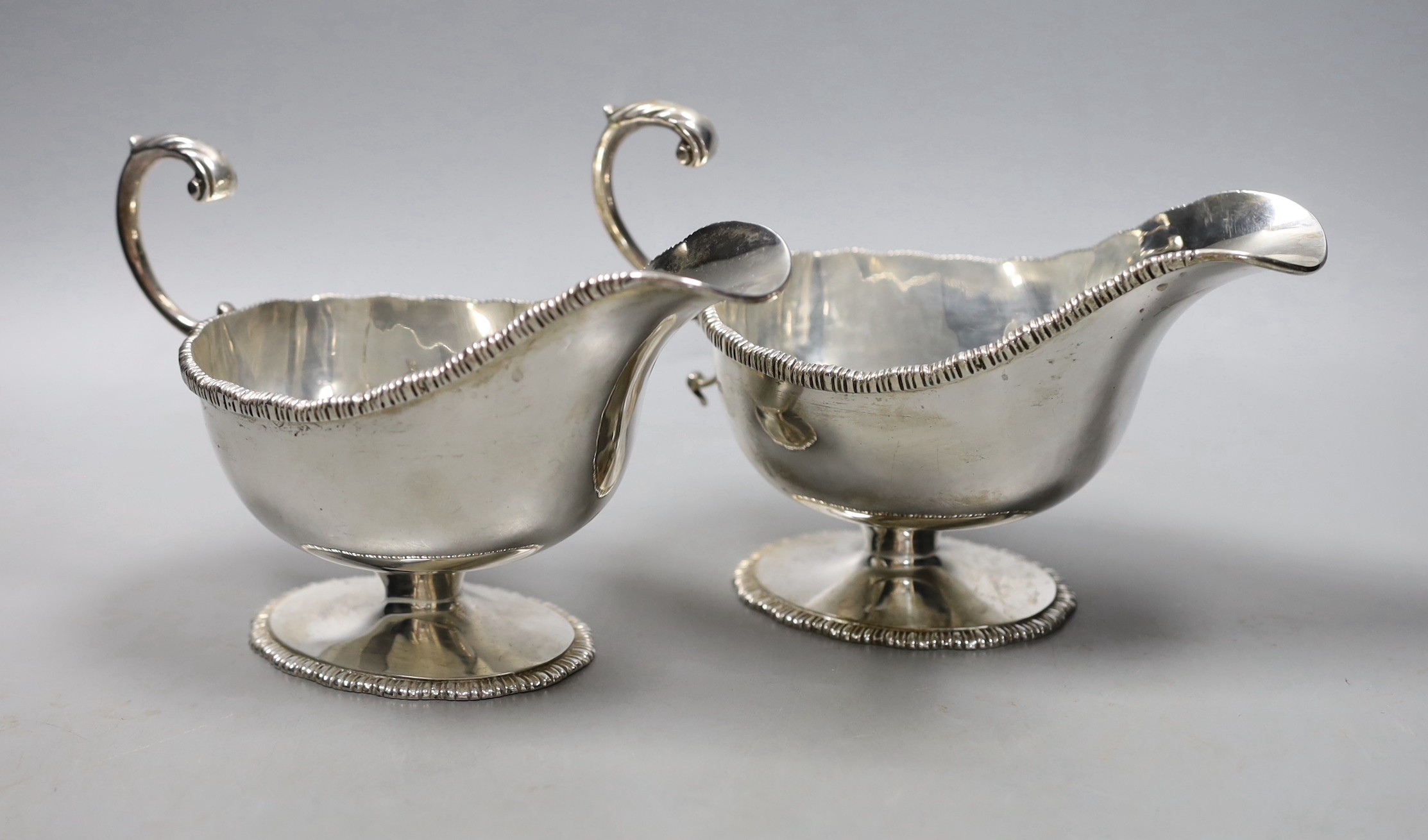 A pair of George V silver pedestal sauceboats with flying scroll handlse, Parker Brothers, Chester 1911, 14oz.                                                                                                              