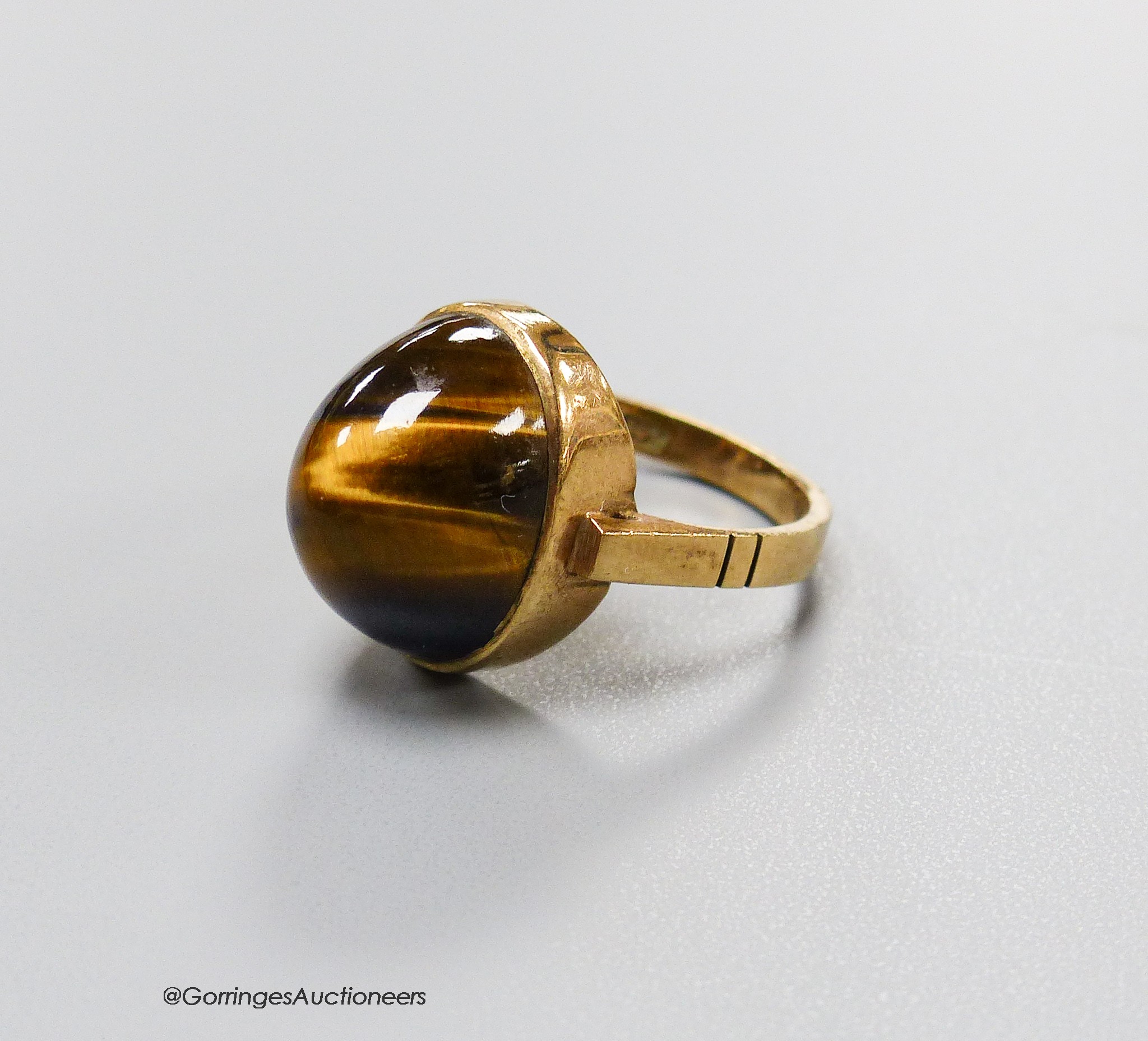 A 9ct and cabochon tiger's eye quartz set dress ring, size O, gross 5.4 grams.                                                                                                                                              