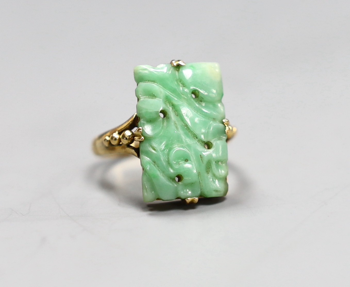 An early 20th century yellow metal Chinese jade plaque ring, size M, gross 4.8 grams                                                                                                                                        