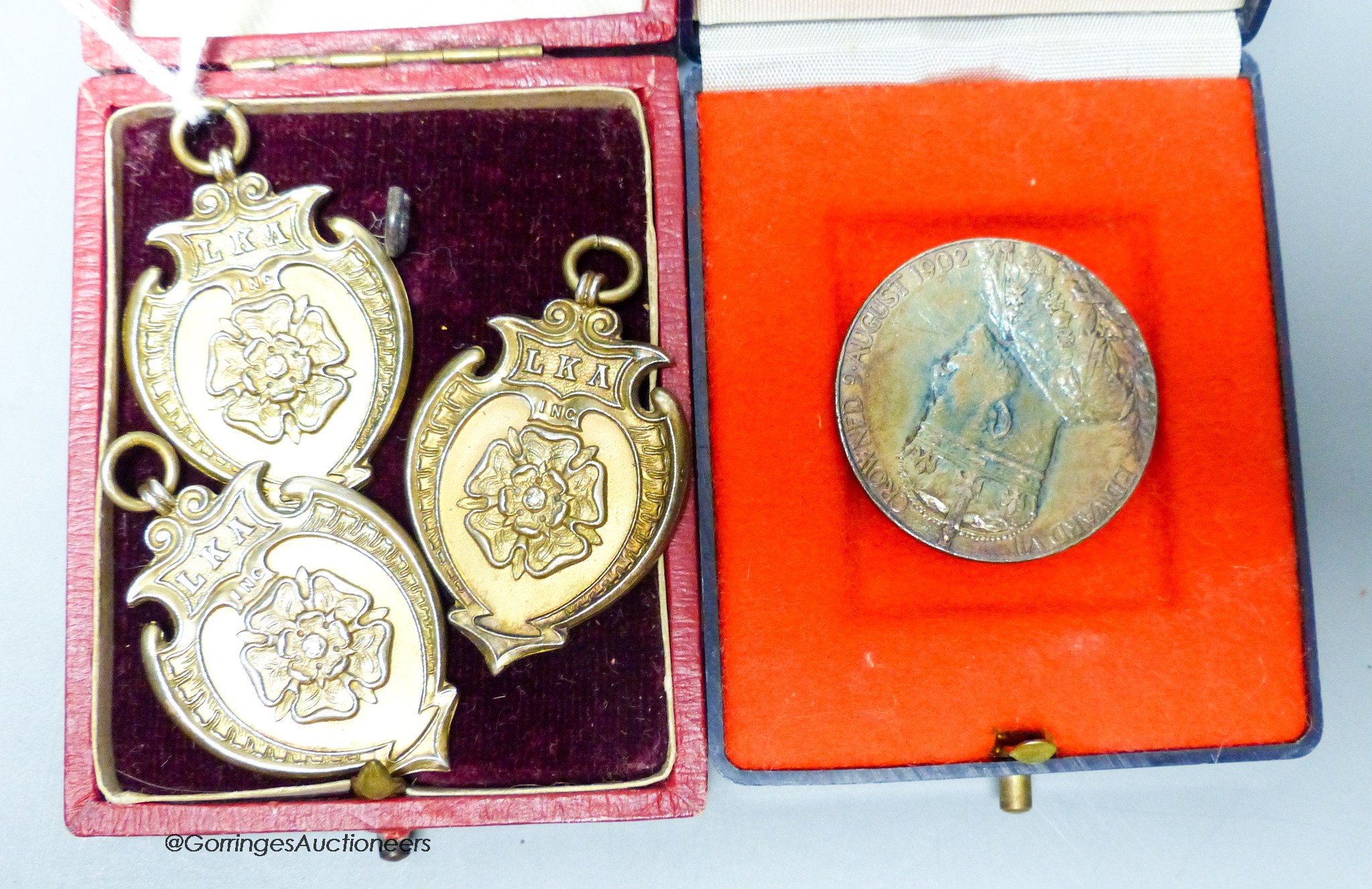 Three silver gilt medals and a George V Coronation medal.                                                                                                                                                                   