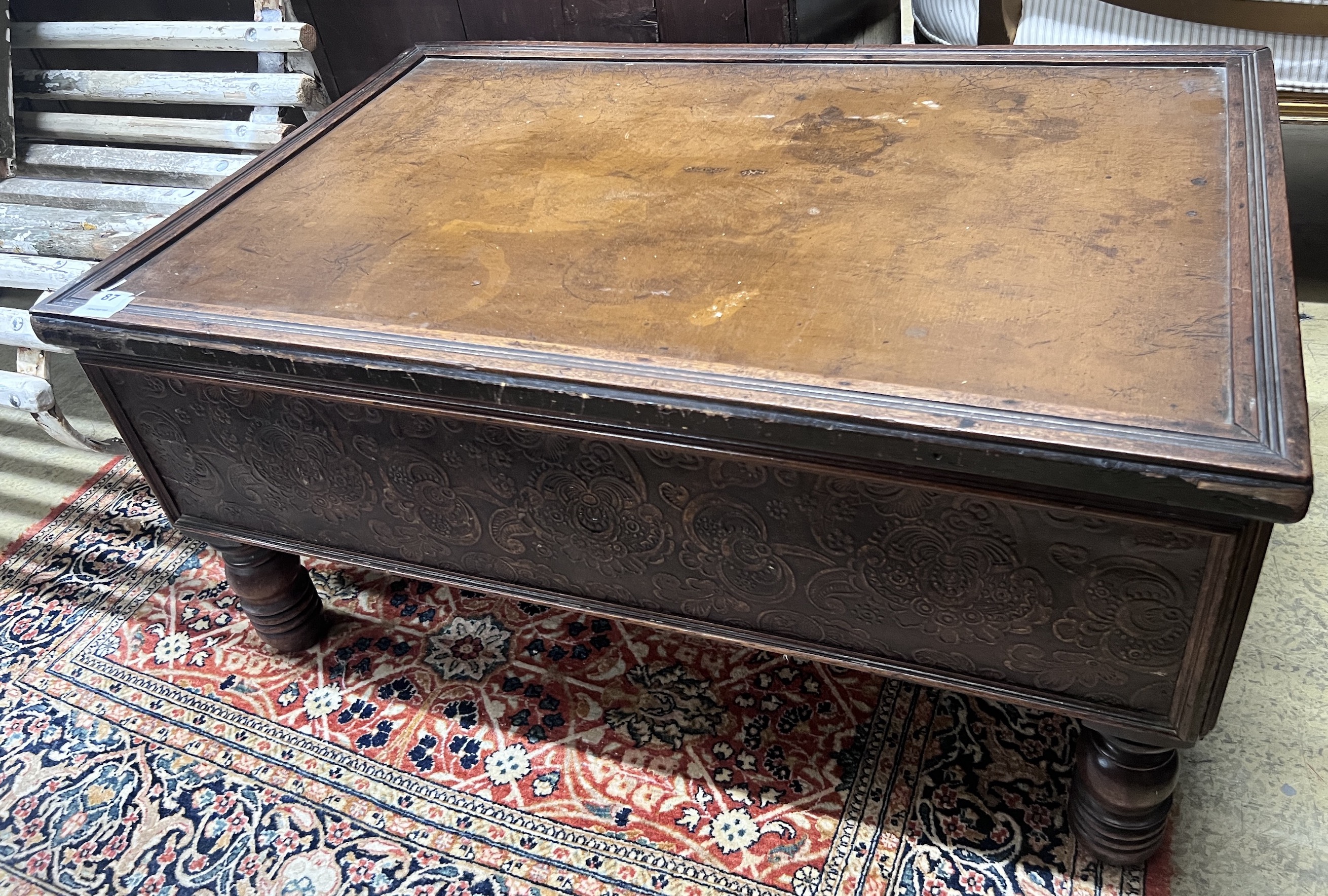 A rectangular embossed leather covered mahogany coffee table on turned feet, incorporates old timber, length 94cm, width 61cm, height 46cm                                                                                  