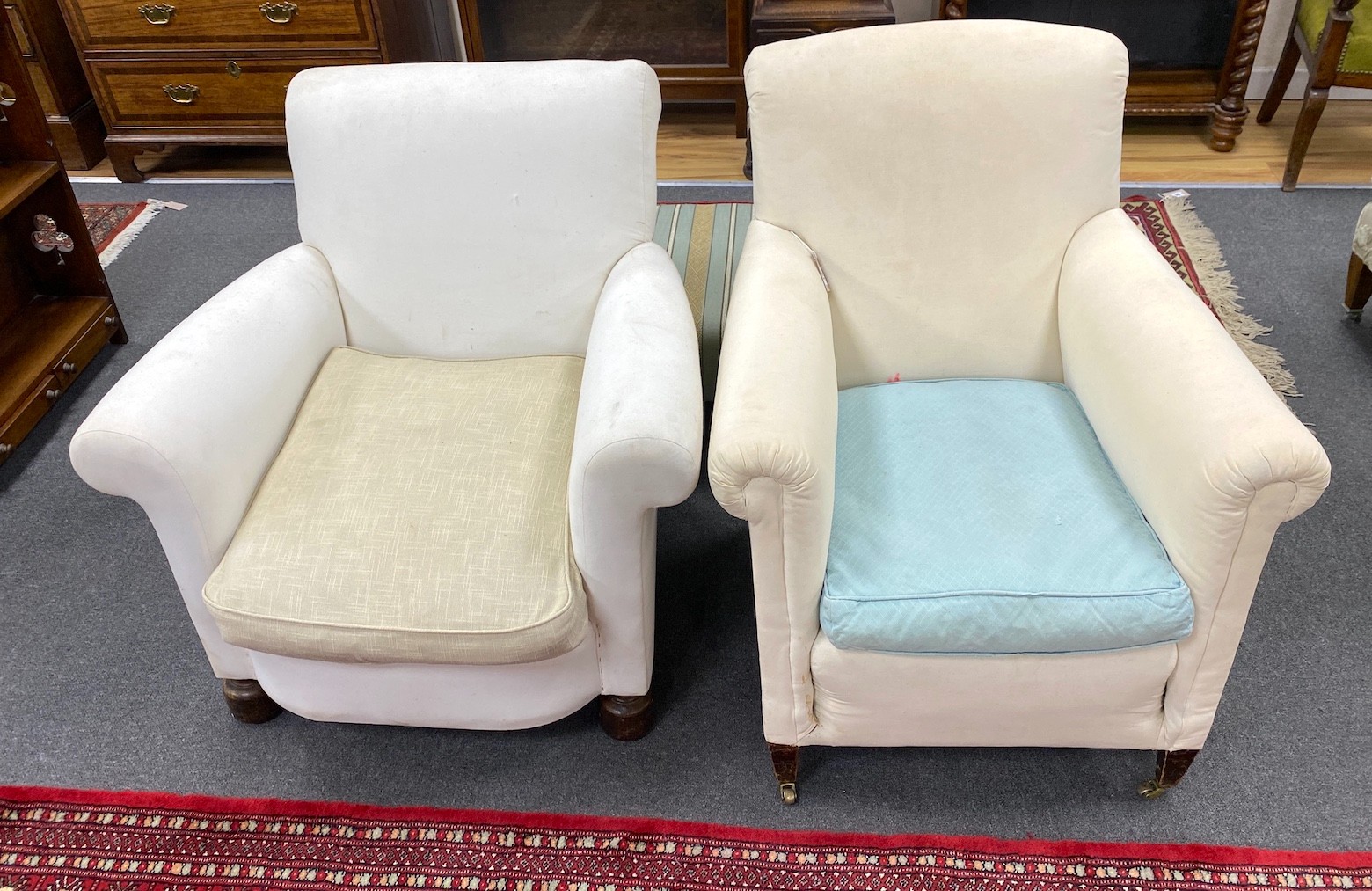 Two early 20th century upholstered armchairs, back legs stamped Howard & Son, Berners St and Howard & Son London. One castor marked H&S, larger width 76cm, depth 86cm, height 79cm                                         