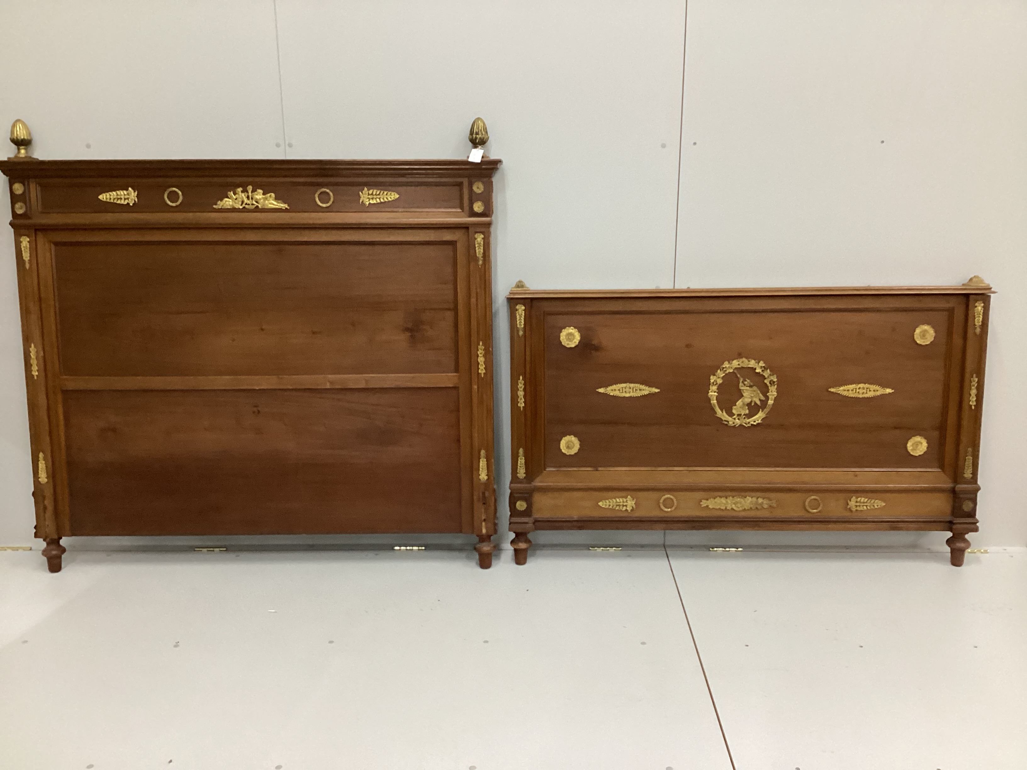 A French Empire style gilt metal mounted walnut head and footboard (no side rails), headboard width 155cm, height 142cm                                                                                                     