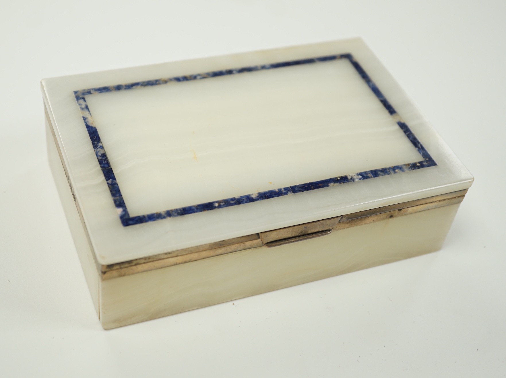 A George V silver mounted, lapis lazuli banded white onyx rectangular cigarette box, George Betjemann & Sons, London, 1919, 15.3cm.                                                                                         