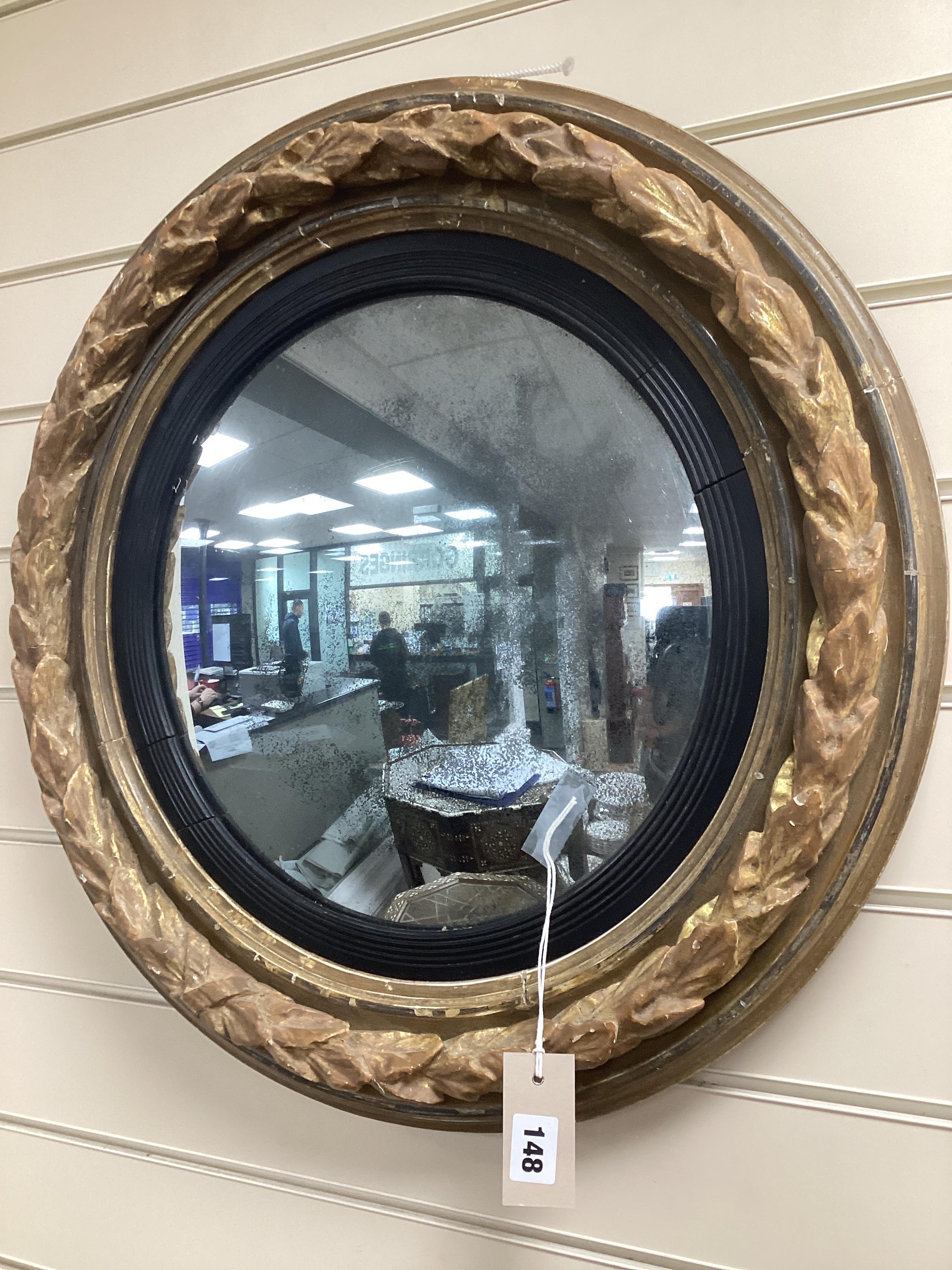 A Regency carved giltwood convex wall mirror with ebonised slip, diameter 58cm.                                                                                                                                             