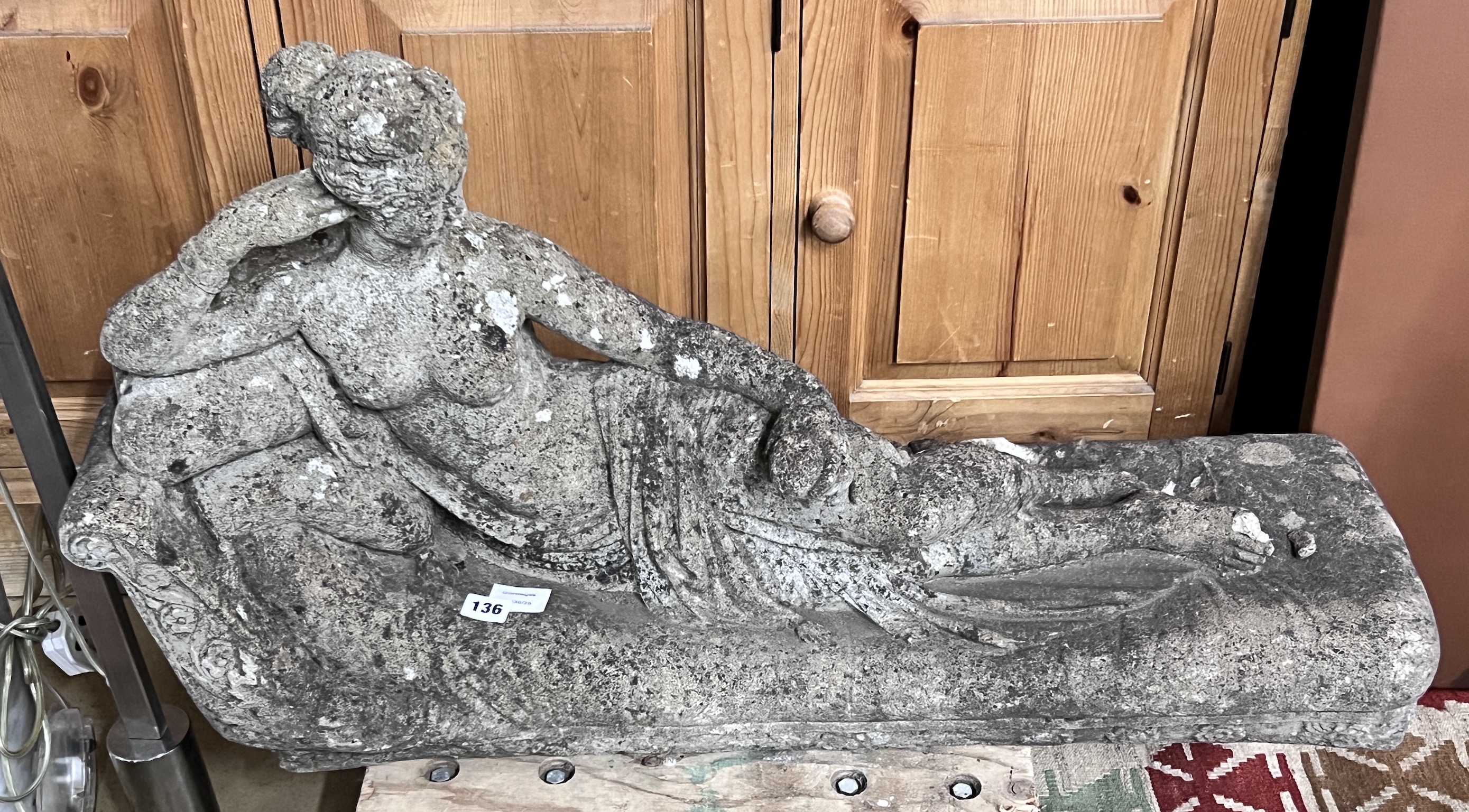 A reconstituted stone reclining female garden ornament, length 90cm, height 50cm                                                                                                                                            