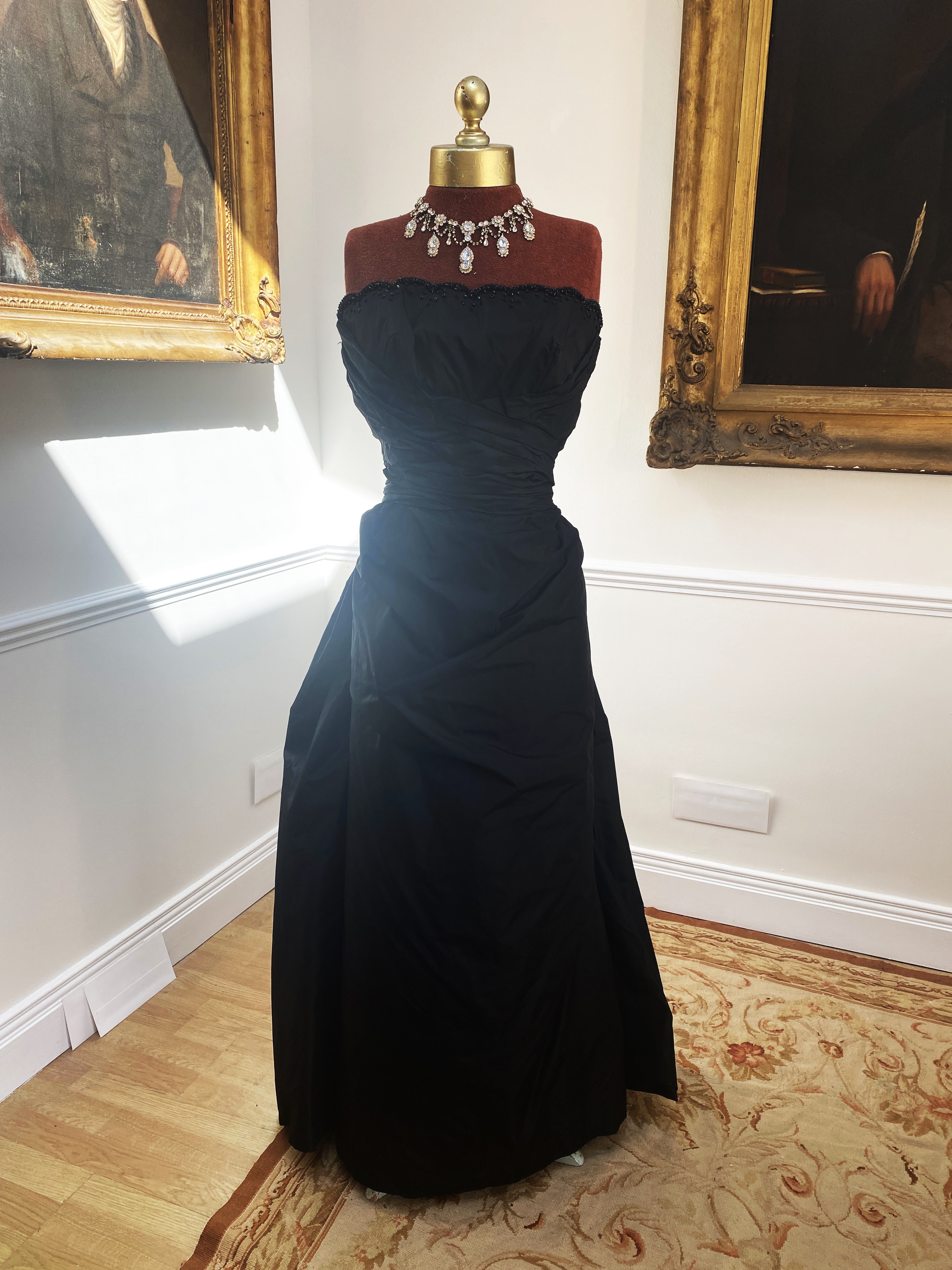 A black taffeta lady’s boned vintage evening gown (possibly 1950’s). Size S – with black velvet jacket                                                                                                                      