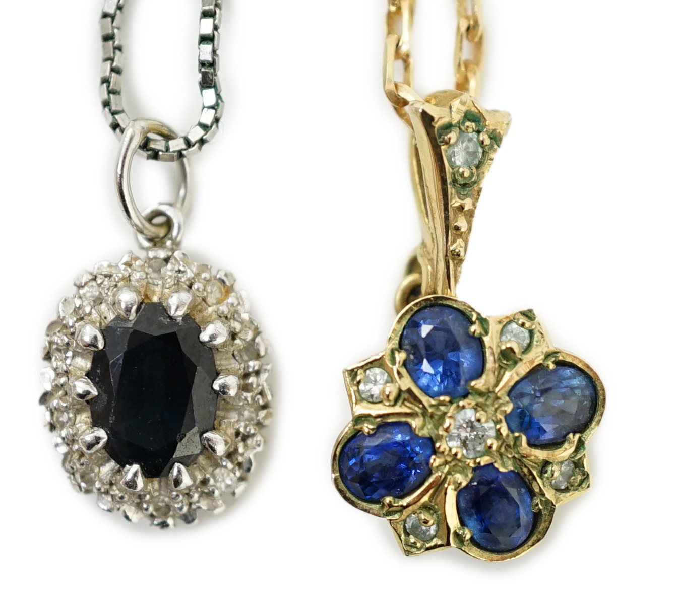 A modern 9ct gold, sapphire and diamond set pendant, overall 19mm, on a 375 chain, 38cm and a similar white metal, sapphire and diamond set pendant, on a 9ct white metal chain, gross weight 7 grams.                      