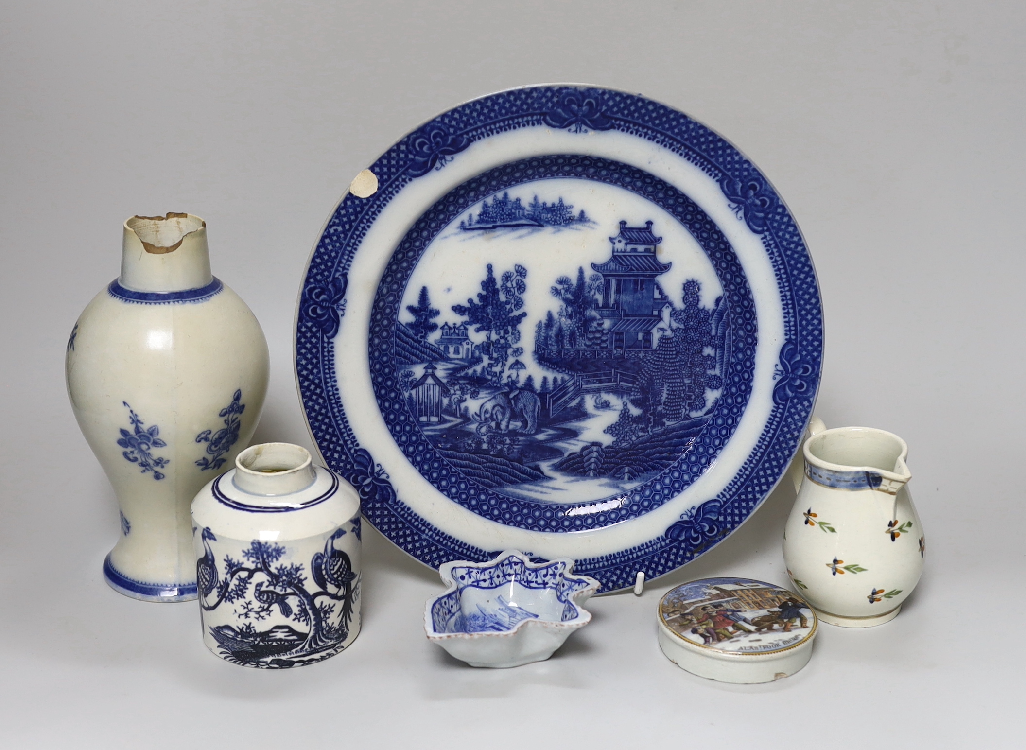 A collection of early 19th century pottery including a good sparrowbeak jug painted with flowers, a vase with blue decoration, a tea canister printed with birds in blue, a leaf shaped dish printed in blue, a pot lid and 